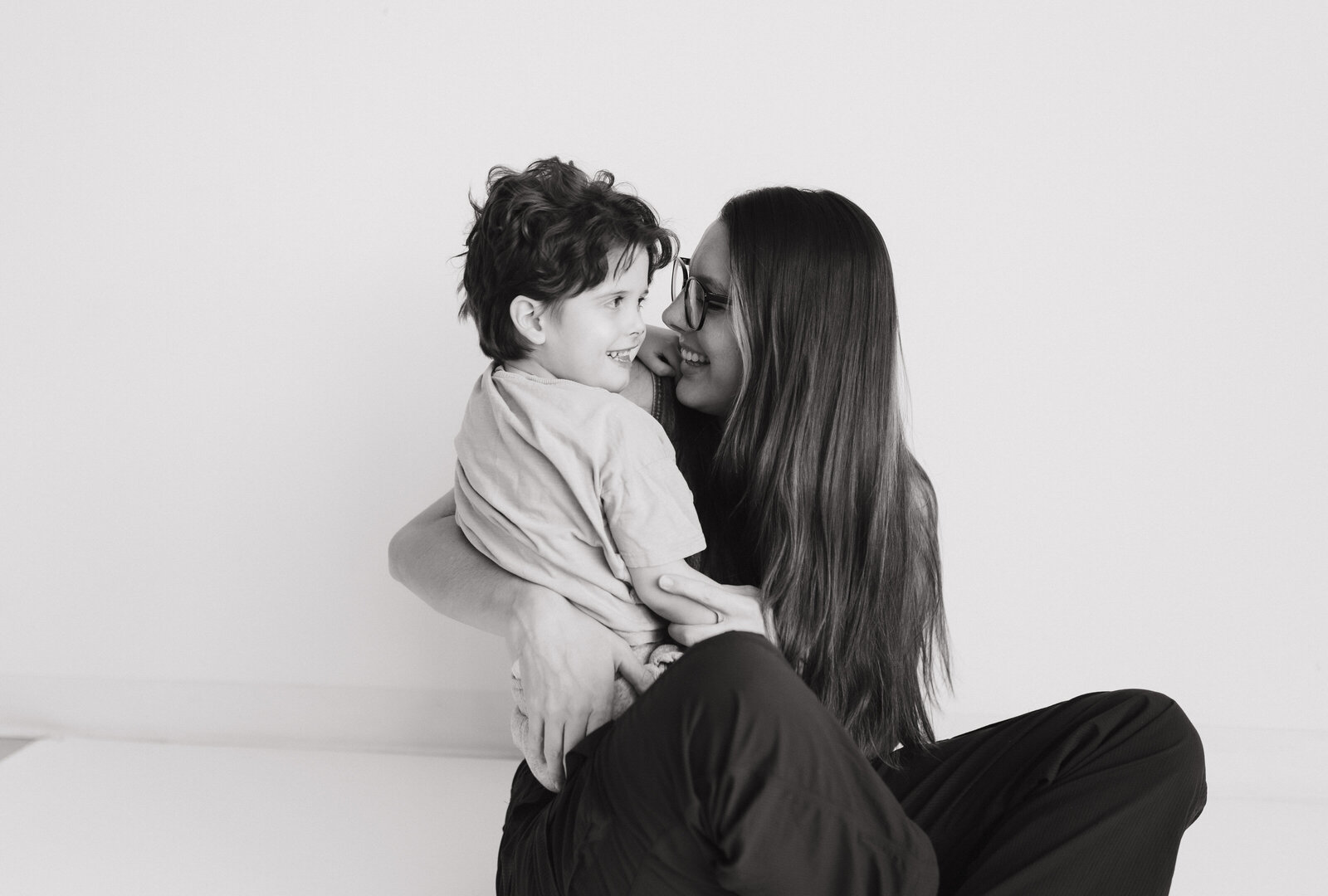 photo of a langley family & newborn photographer holding her toddler while smiling at each other taken in langley