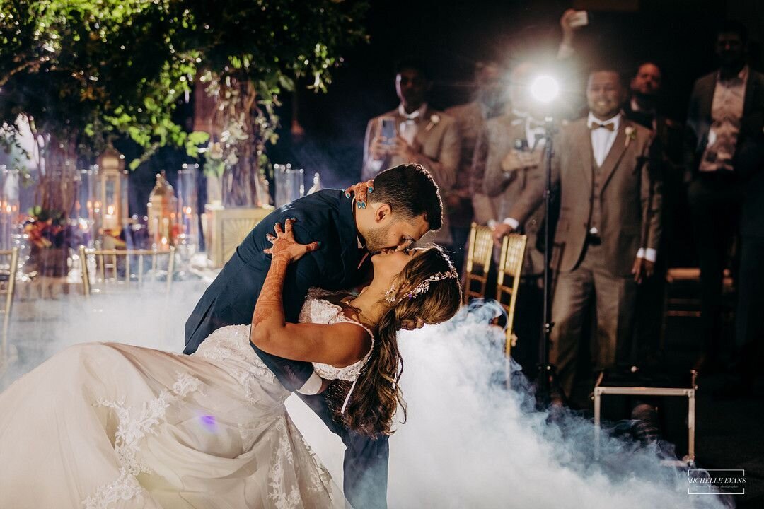 Romantic first dance at multicultural wedding reception featuring bride and groom dip kiss surrounded by fog, candlelight, and elegant décor, captured during an Indian-American celebration styled by Wells Design Co in Memphis, TN.