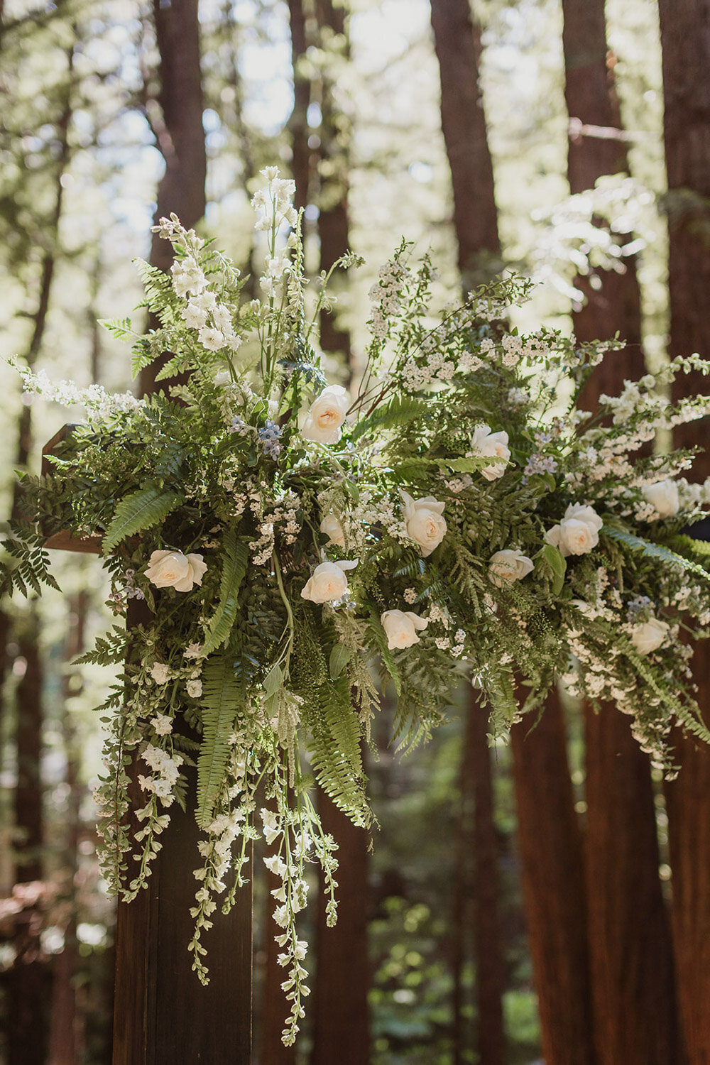 Wedding arch decorated with white roses and greenery