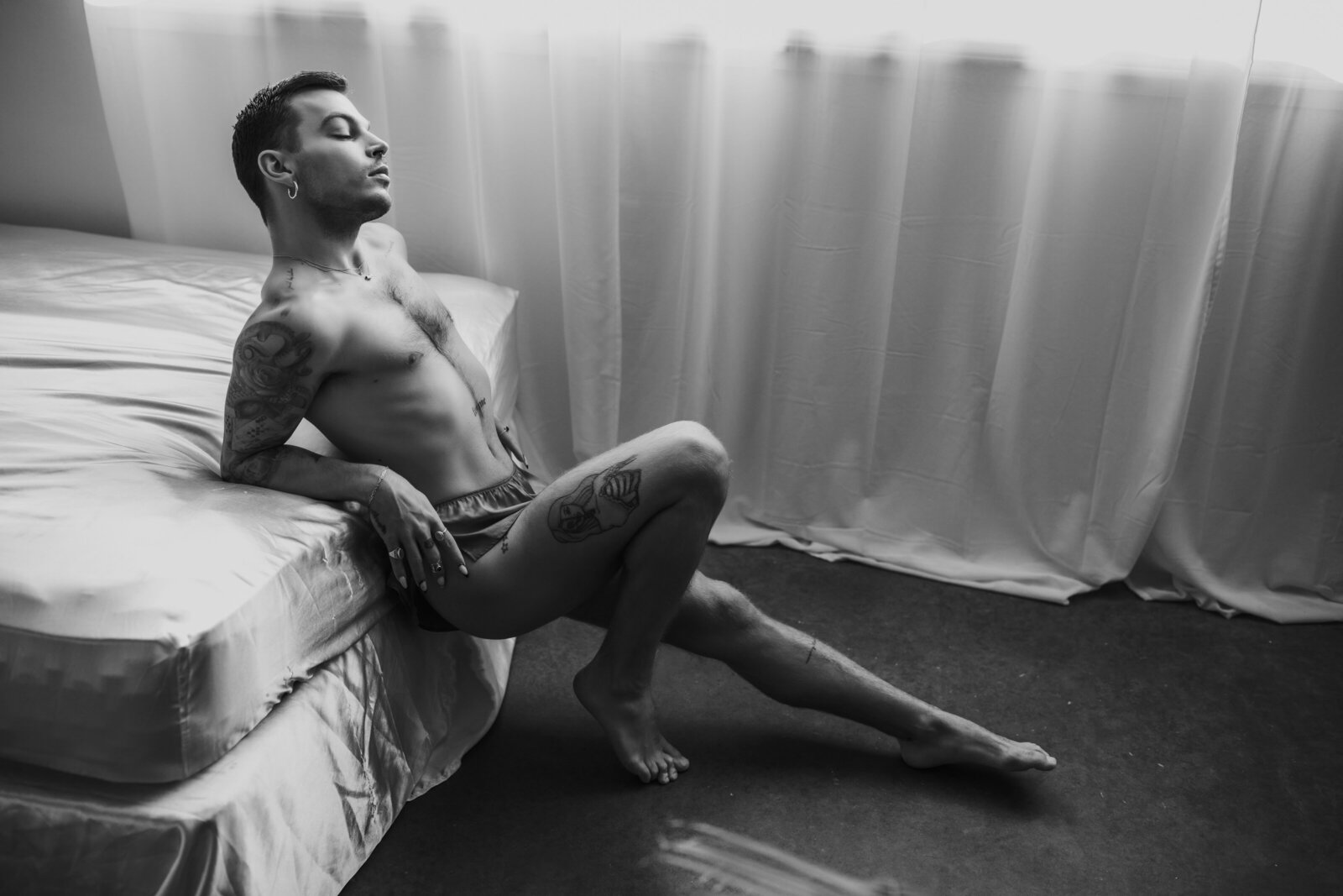 male boudoir model posing on bed in vancouver boudoir photo studio