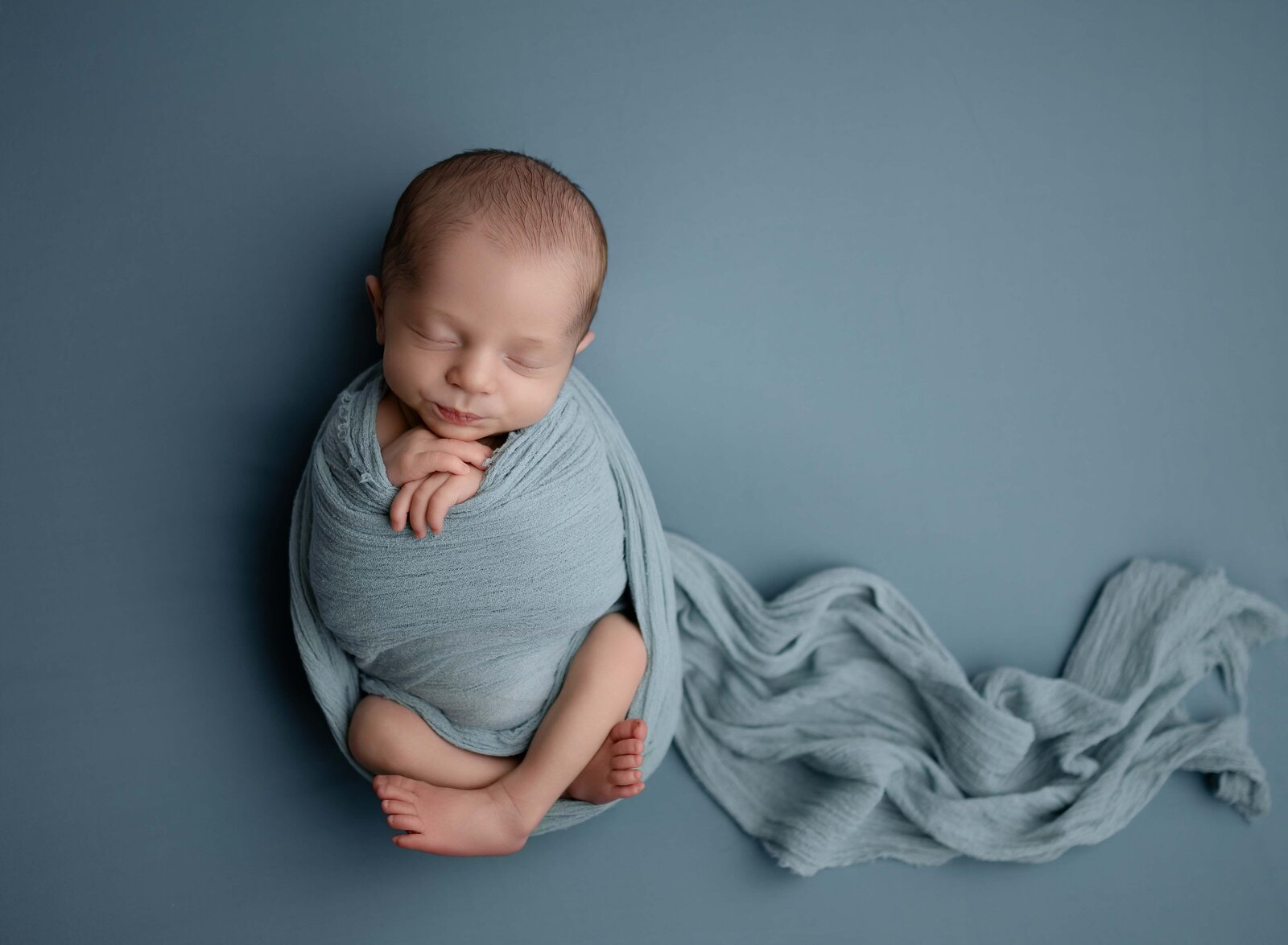 Baby boy sleeping and swaddled in blue blanket. Photo by Jenni Nikki Photography, Marietta Baby photographer.