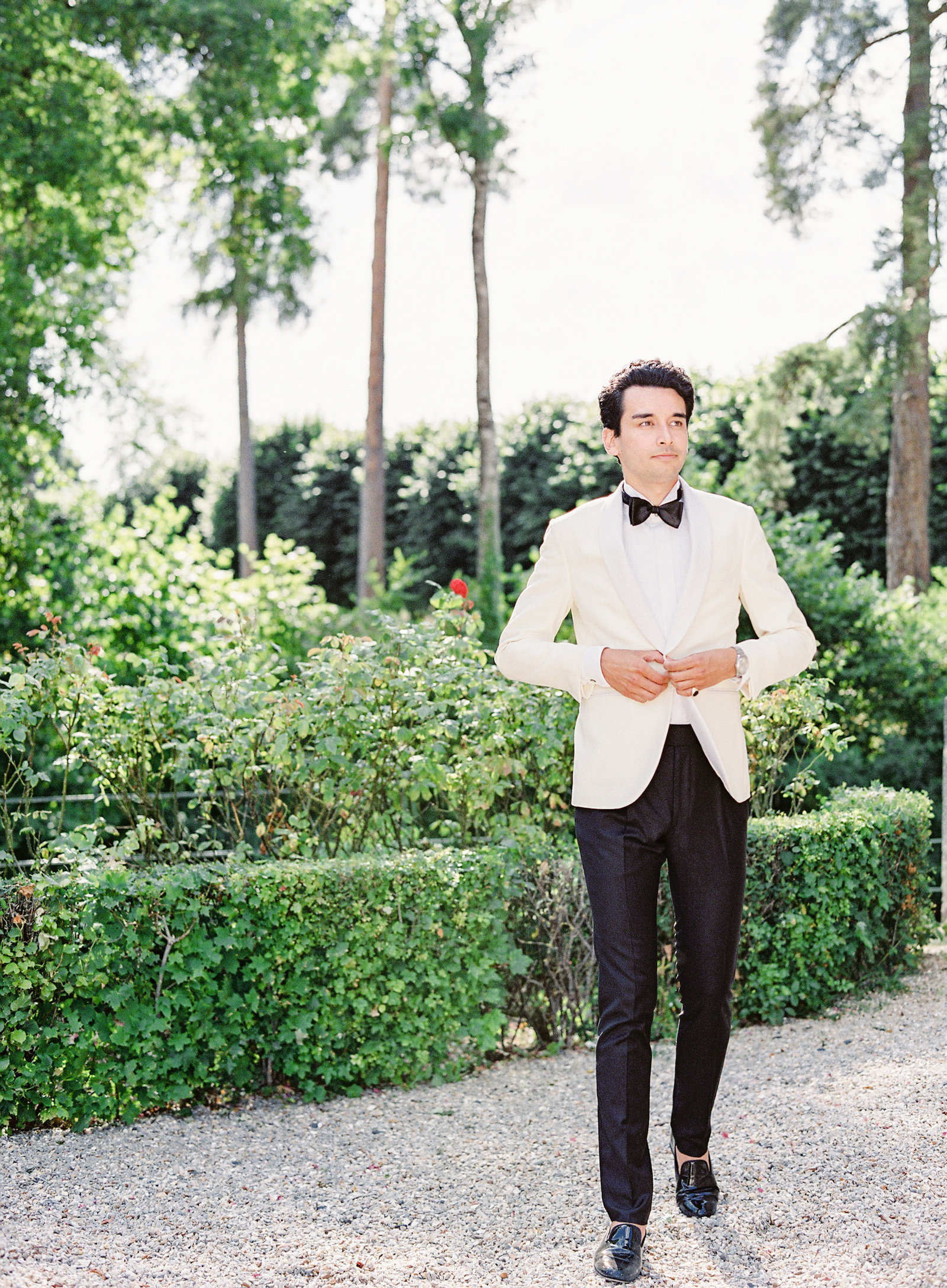 Groom in white dinner jacket walking. Photographed by Amy Mulder Photography