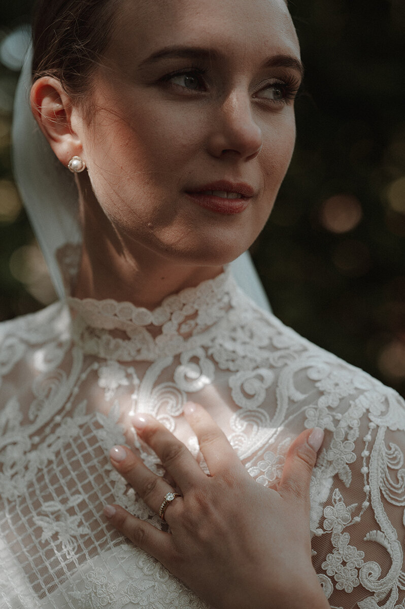 Brud blickar utåt och visar sina detaljer på spetsklänningen