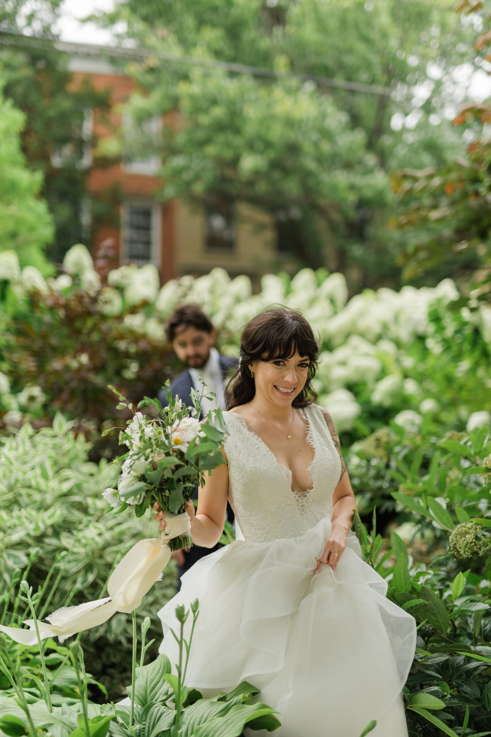Bride runs toward with beautiful bushes background