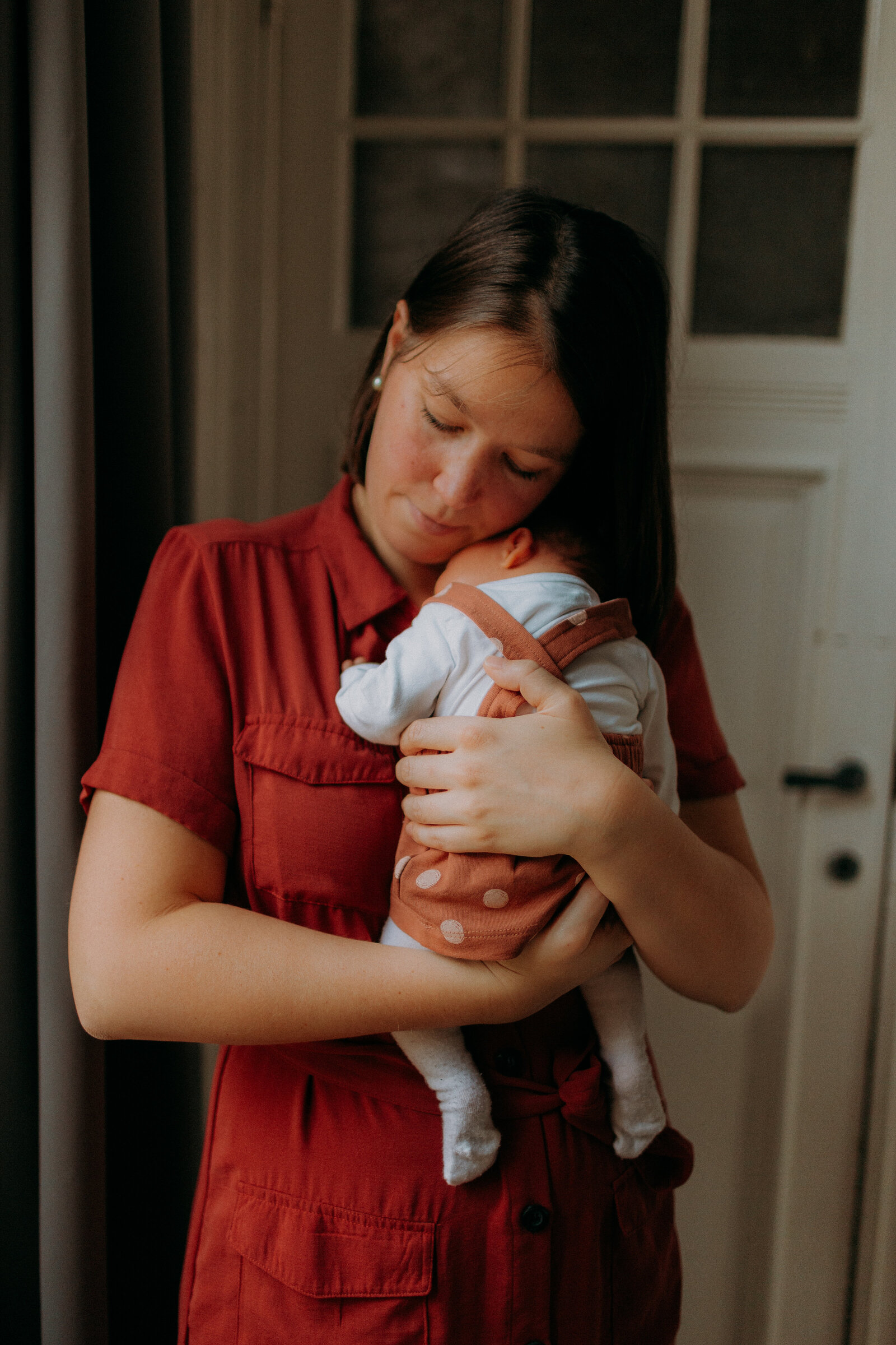 Baby dichtbij houdend tijdens newbornshoot
