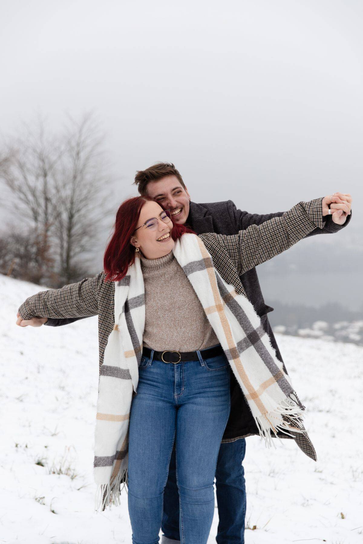 Séance de couple dynamique et pleine d'amour dans la neige sur les hauteurs du lac de Paladru en Isère.