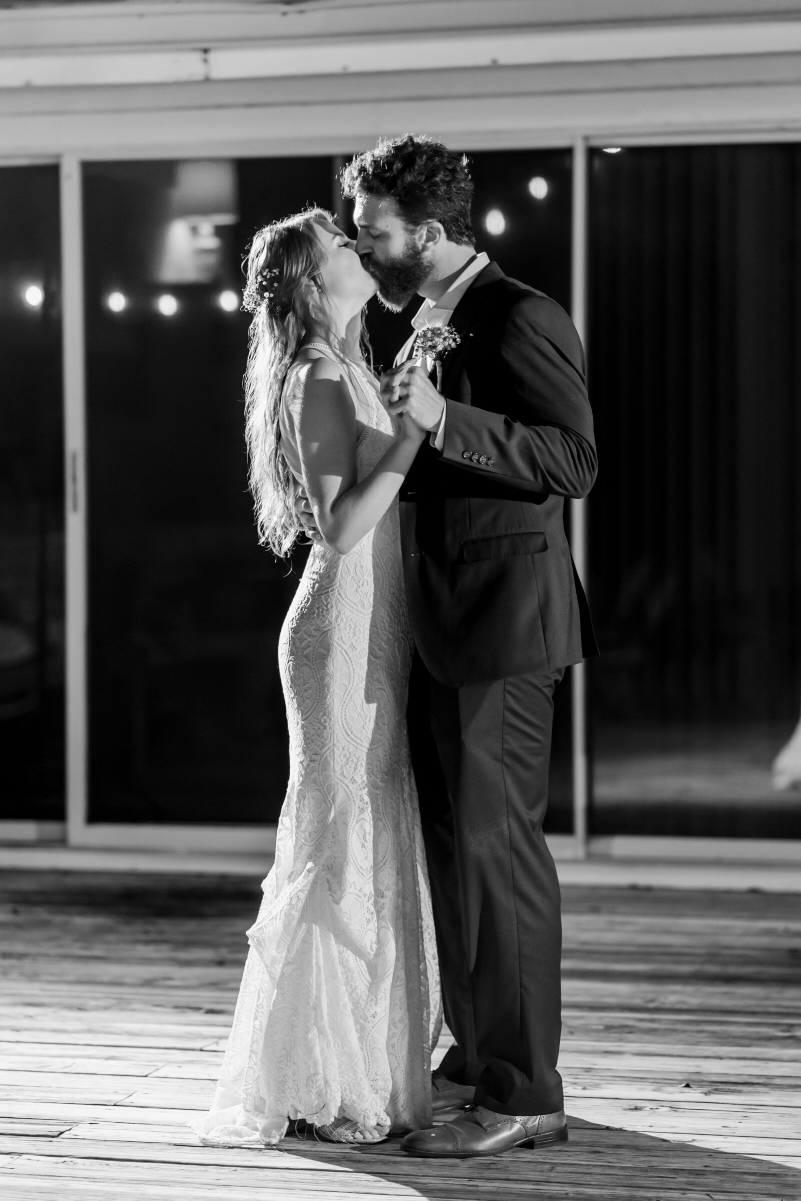 black and white photograph of bride and groom kissing during their first dance at their wedding reception