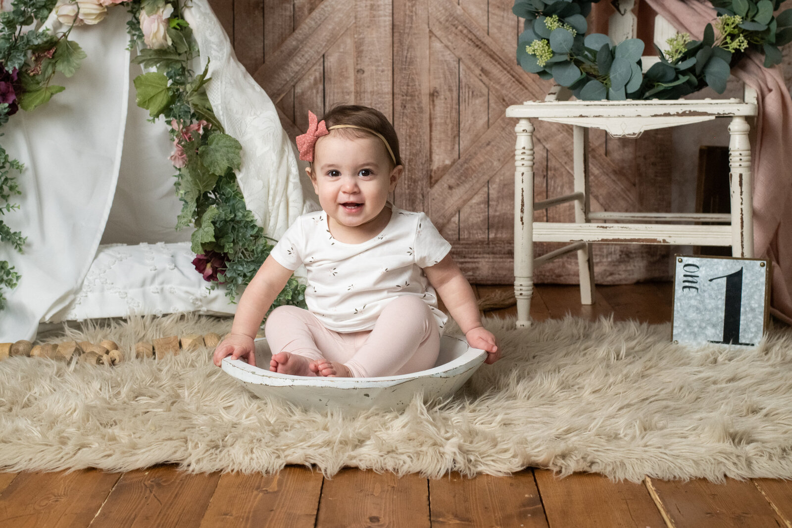 Smiling baby girl sitting in shallow dish