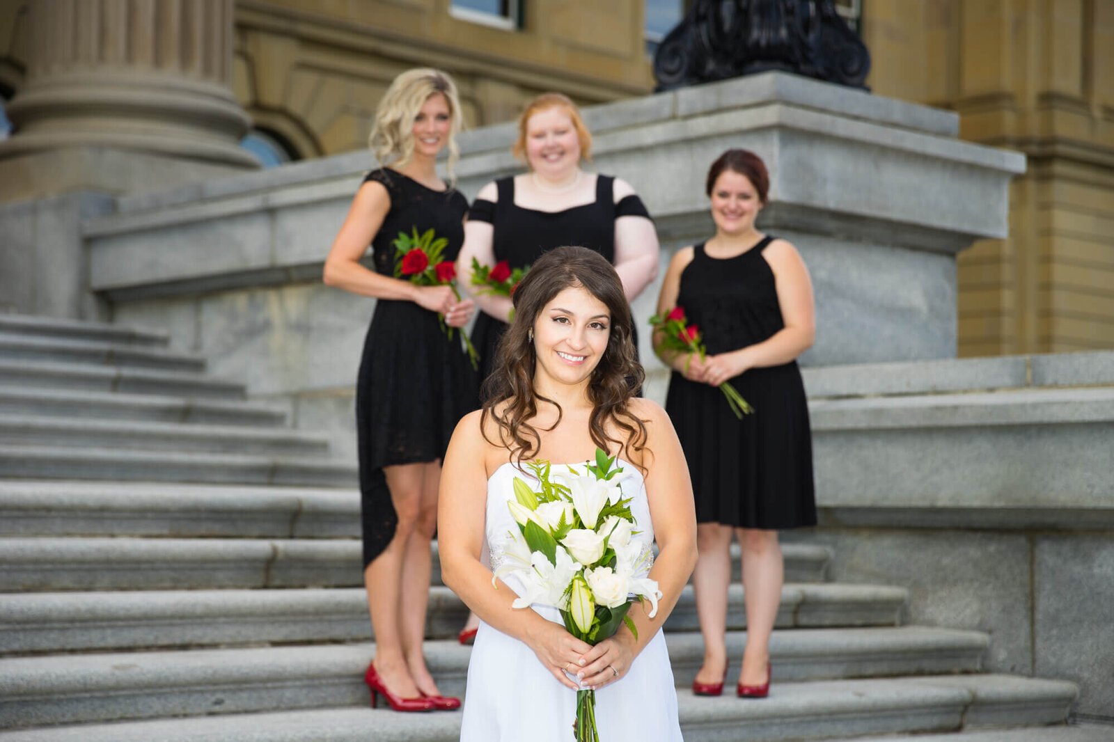 Bride posed with bridesmaids in bakground