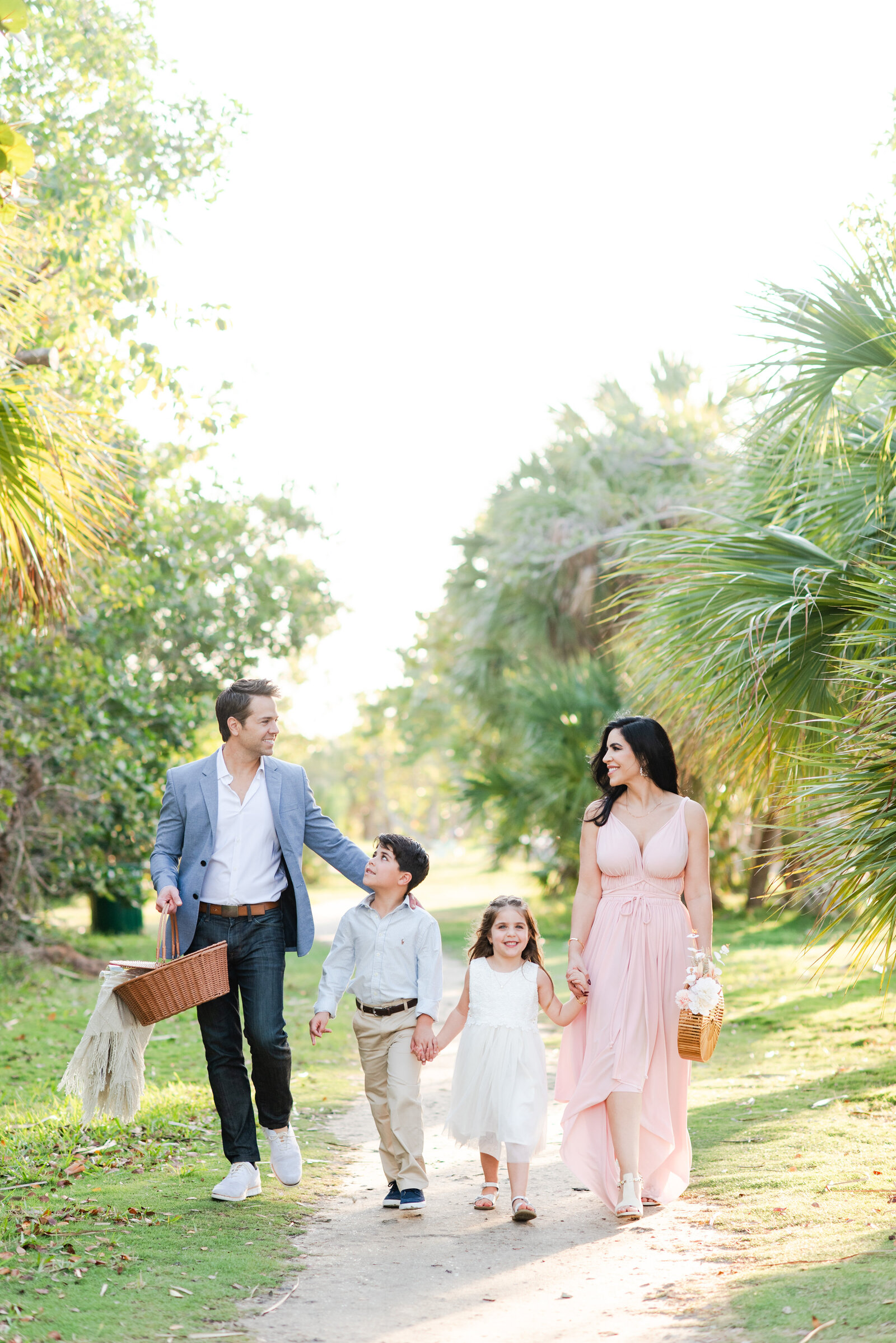 mom and dad with two young kids picnic family session at hugh birch state park Miami lifestyle photographers David and Meivys of MSP Photography