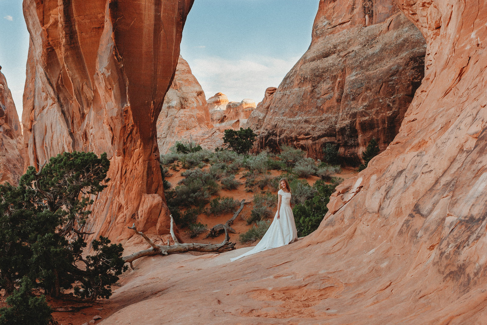 bride standing in desert red rock canyon