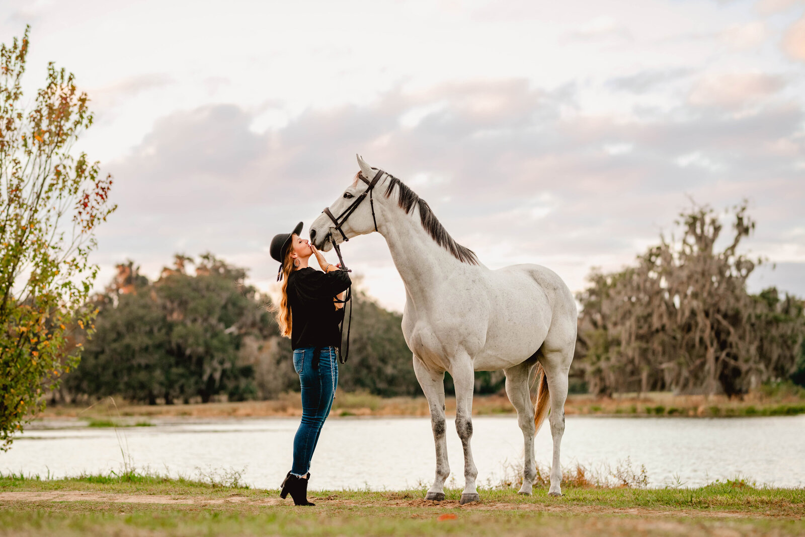 Gainesville, Fl equine photographer takes photos of grey thoroughbred in front of a lake.