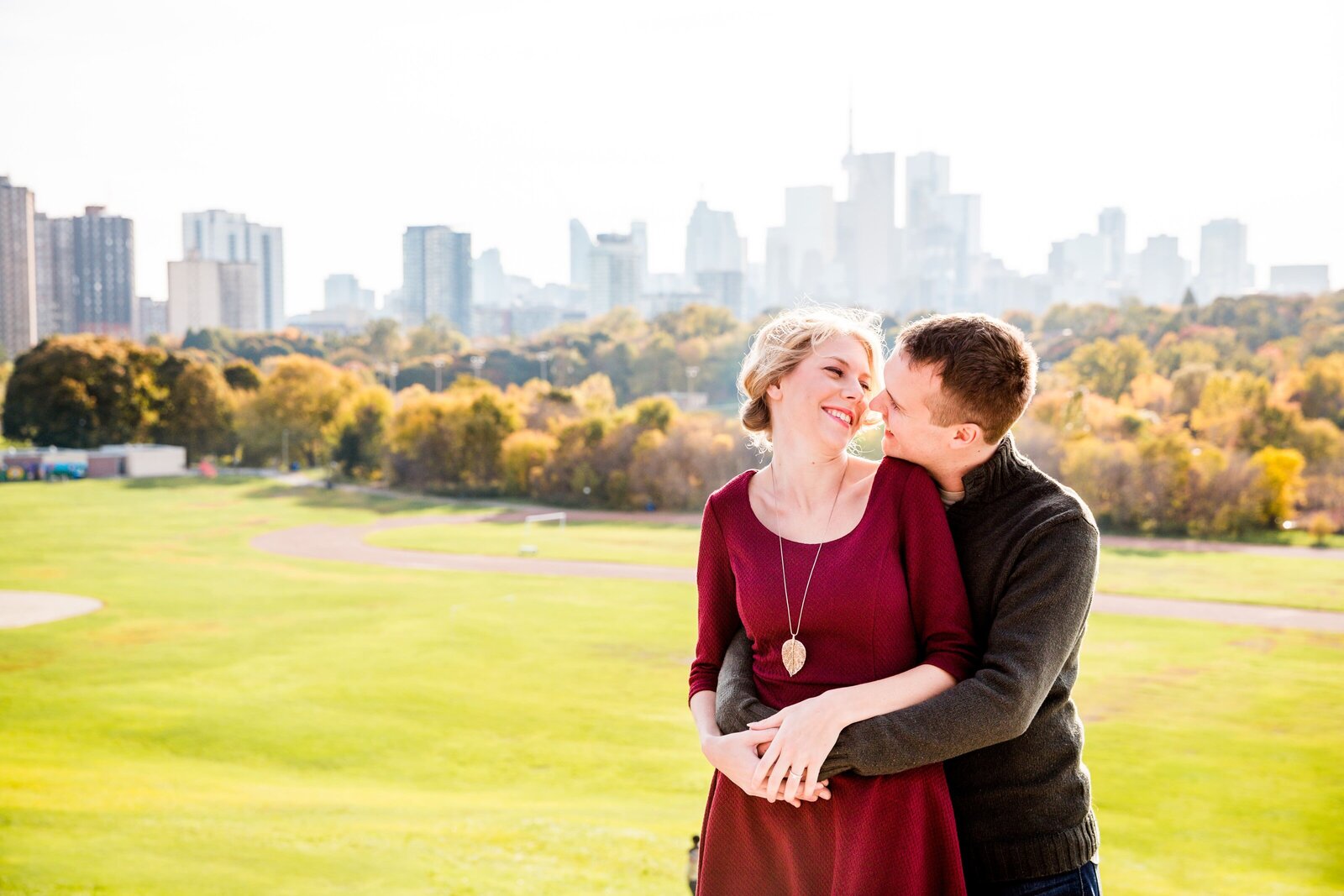 Couple smile at each other atop Riverdale Park in Toronto.