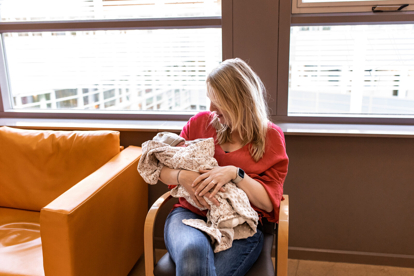 Een geboortefotograaf houdt een pasgeboren baby vast.