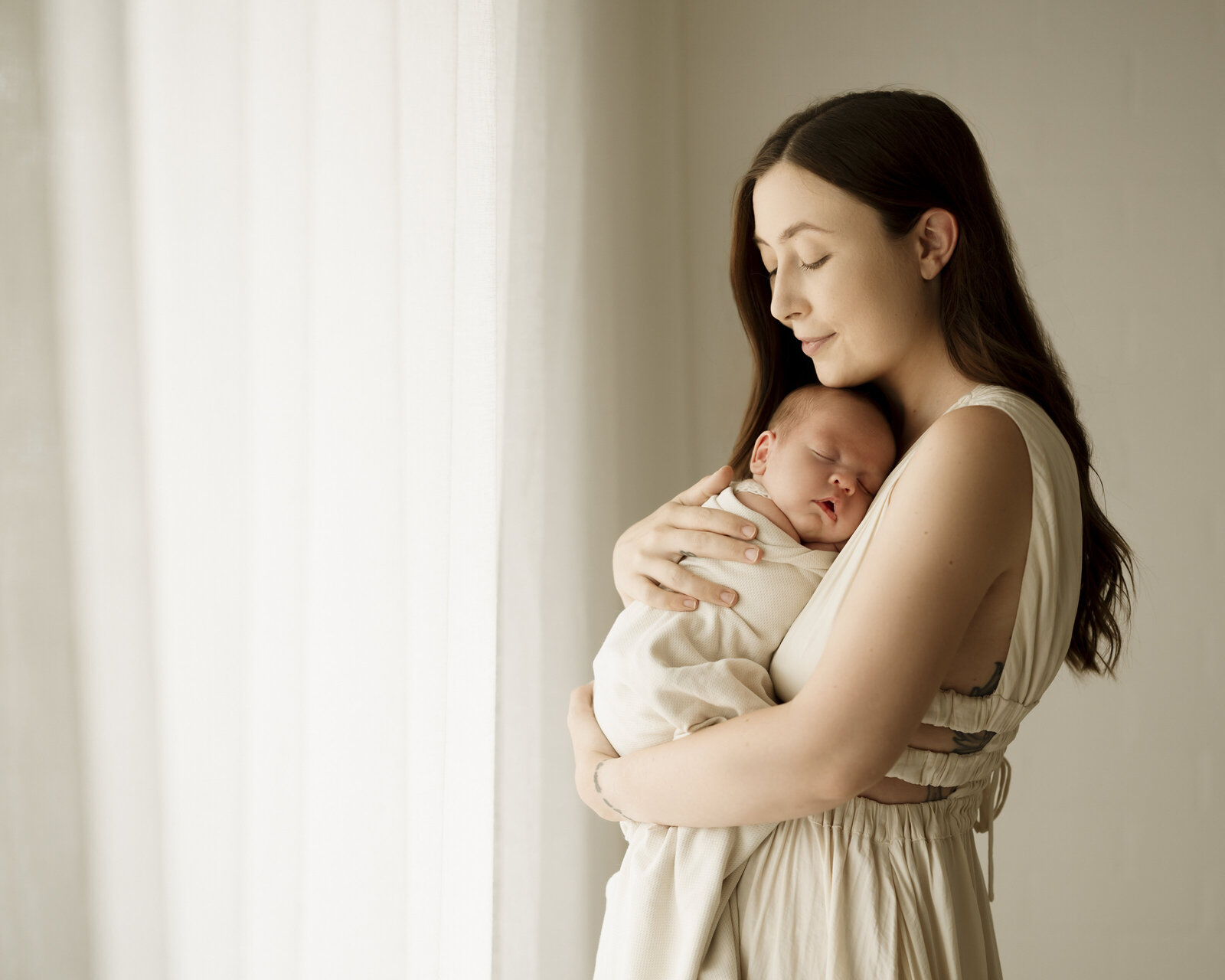 A peaceful and elegant Perth newborn studio photography session, highlighting the bond between baby and parents.