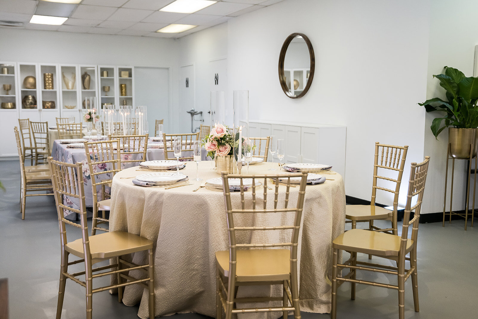 Elegant table setup at The Parlor at Wells in Memphis featuring round tables with neutral linens, gold chiavari chairs, and soft floral decor—ideal for intimate events and private celebrations.