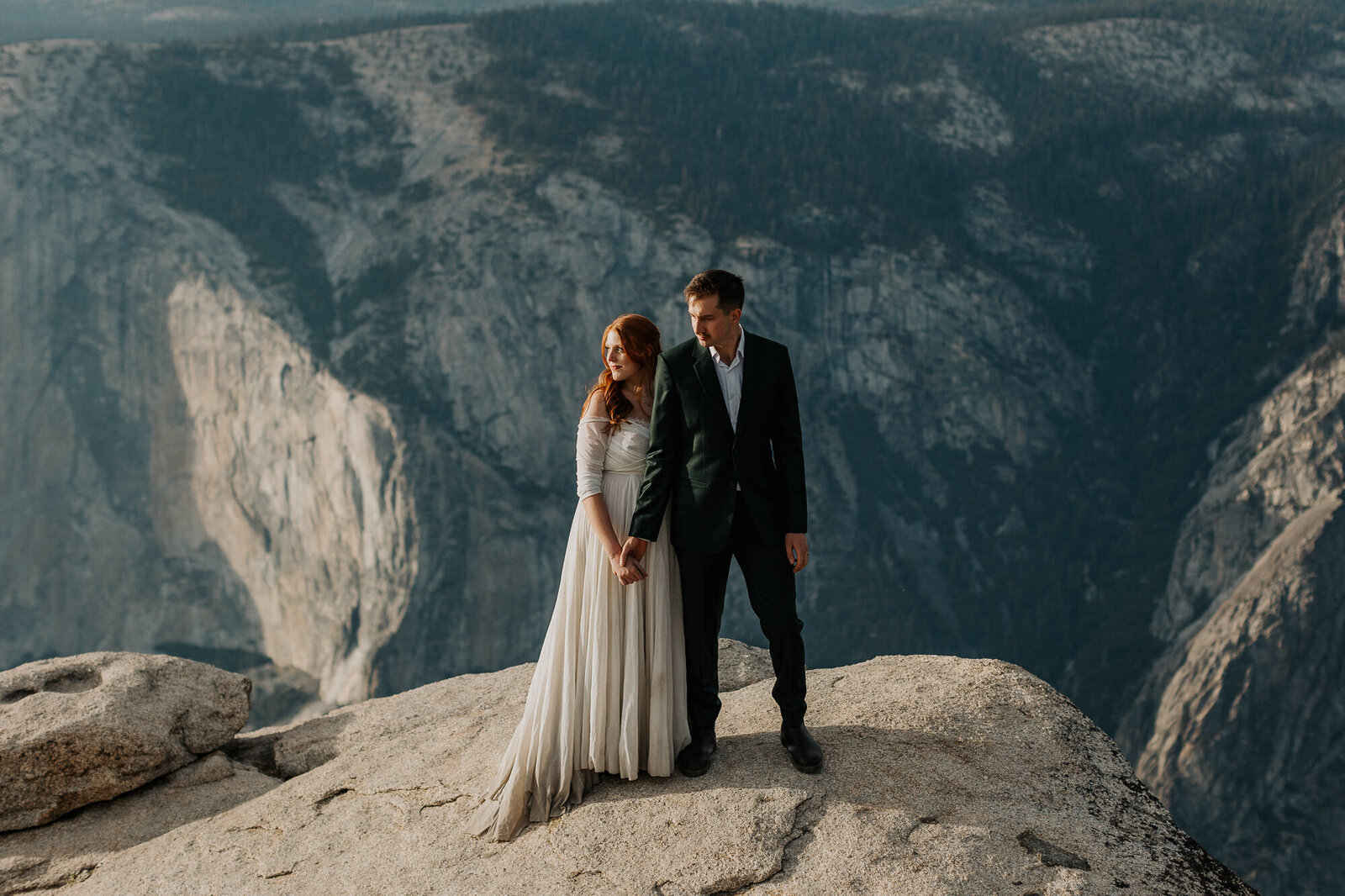 Couple hold hands at Taft Point for their Yosemite adventure wedding