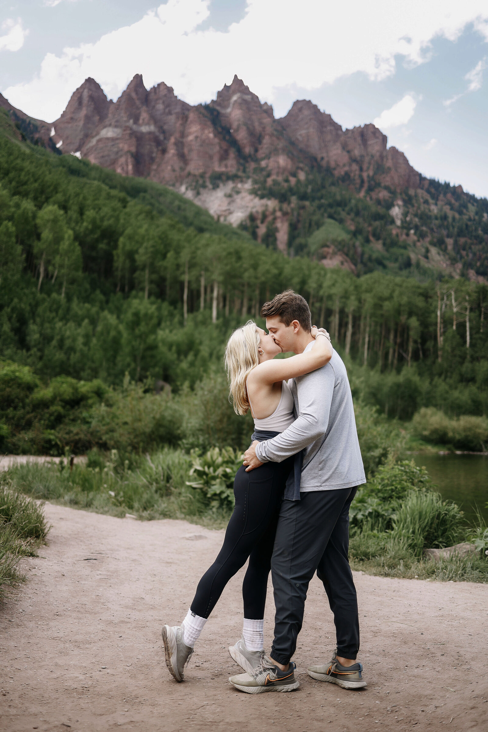 A young couple kisses after they just got engaged at the Maroon Bells, in Aspen Colorado,