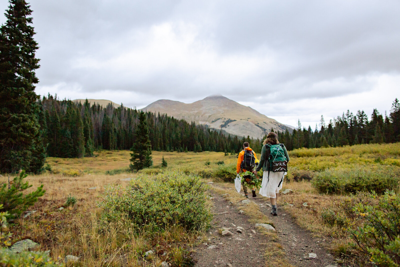 Bride and groom hike back down the trail after their elopement