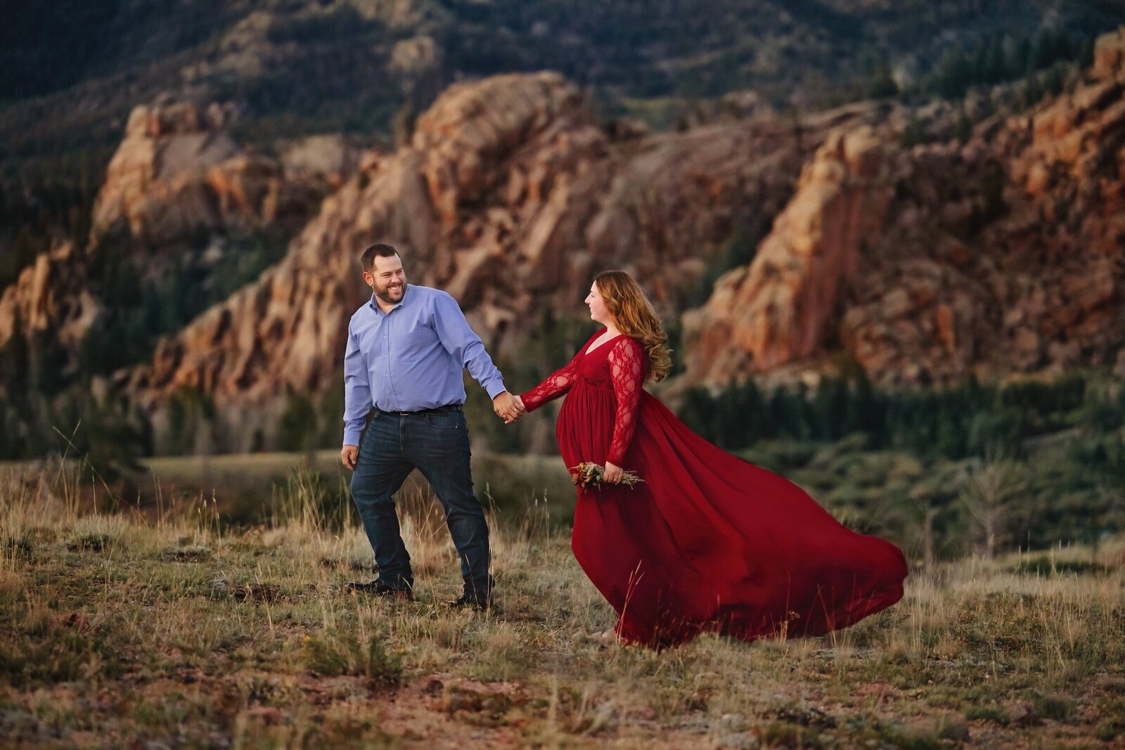 Expectant couple holding hands in Vedauwoo on a beautiful summer evening