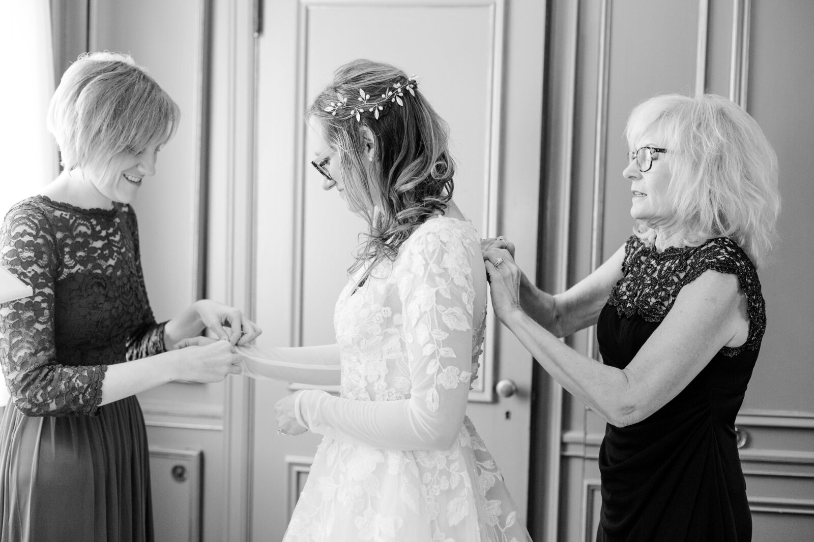A candid moment between a bride, her mother and sister at Tulsa's Dresser Mansion.