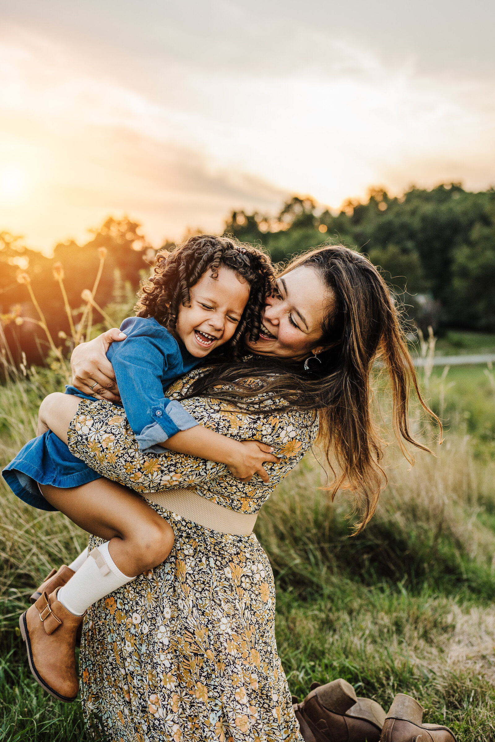 mom and daughter laugh together at family photoshoot