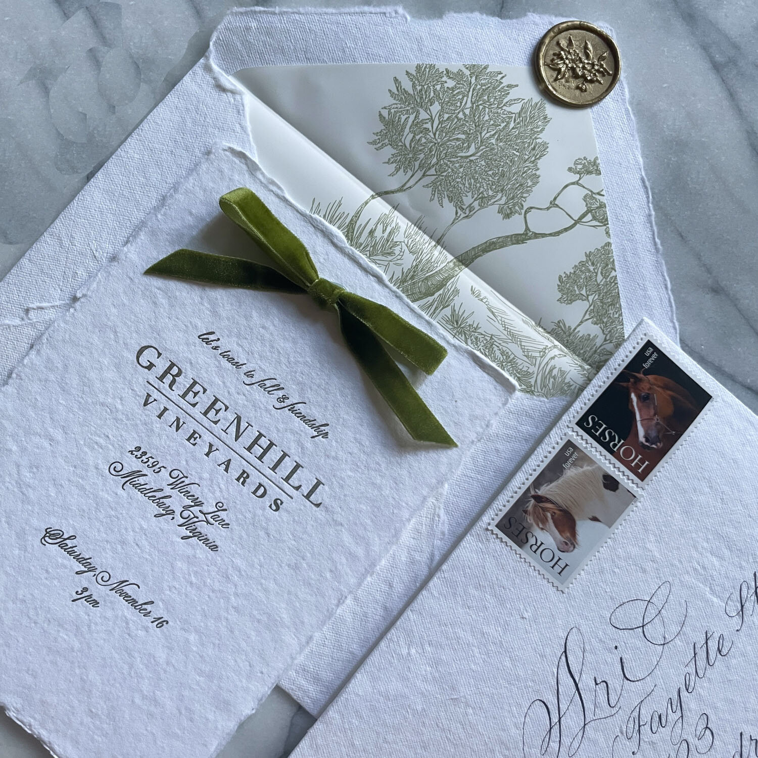 Elegant wedding invitation with torn edges and a green ribbon.