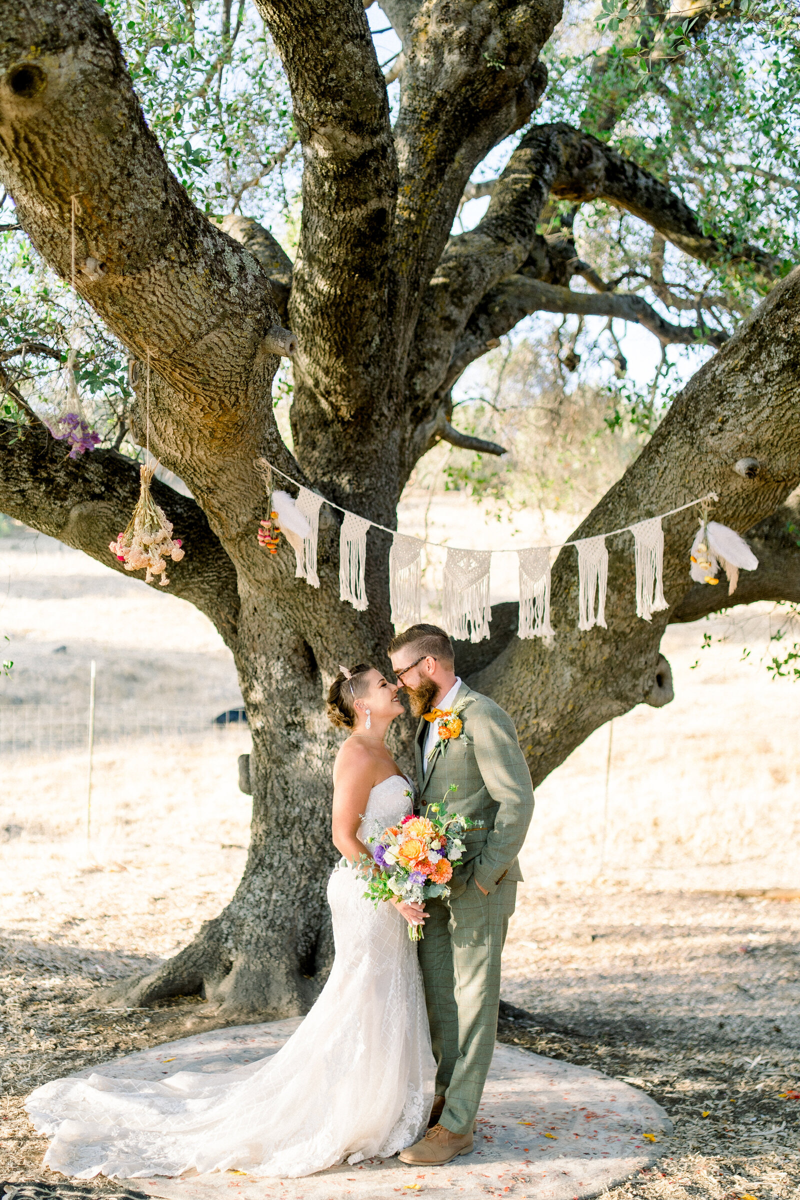 Bride and groom under the oak tree at their wedding at The Maples in Woodland, CA