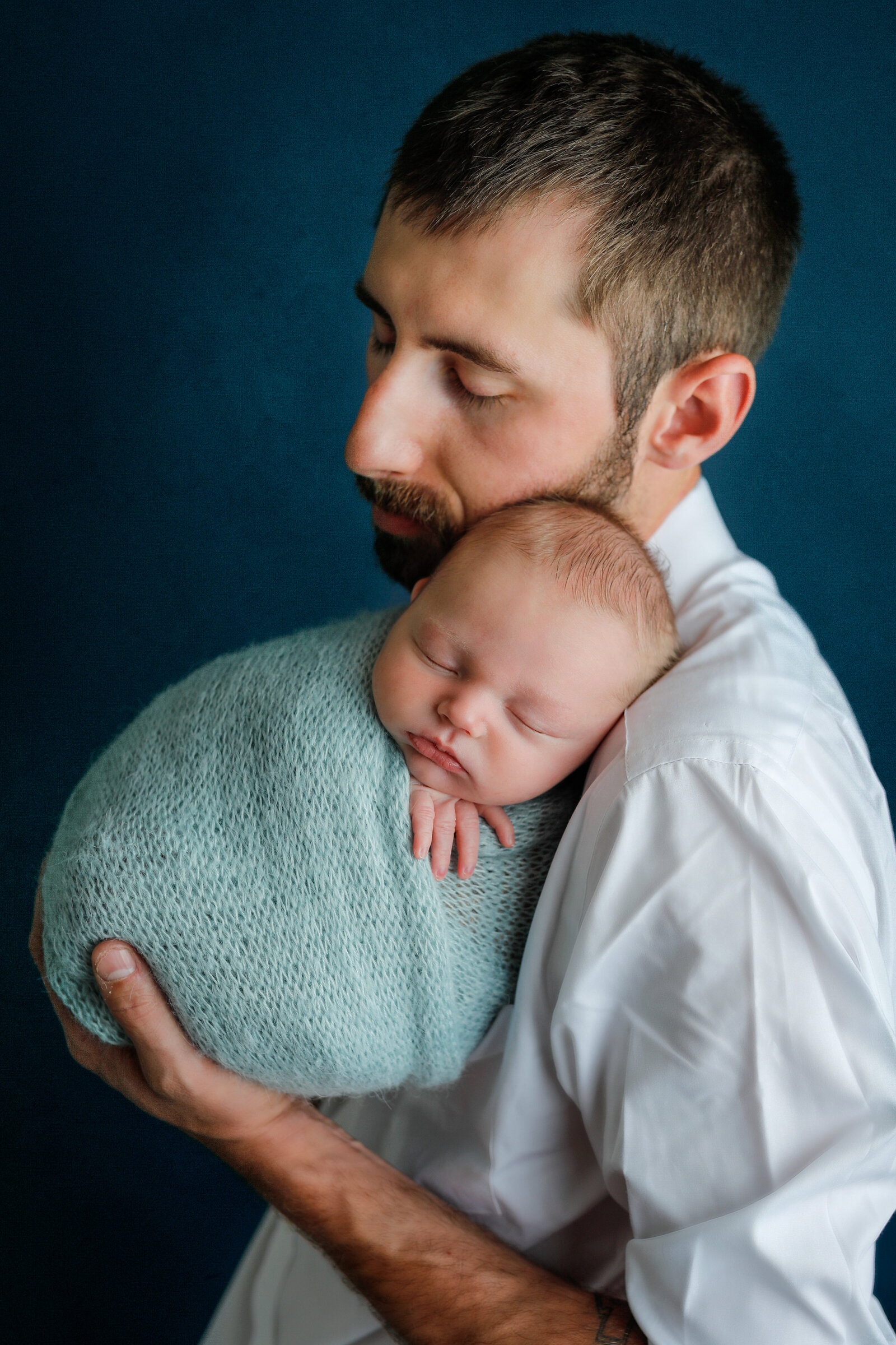 Fatherhood-new-dad-holding-baby-blue-wrapped