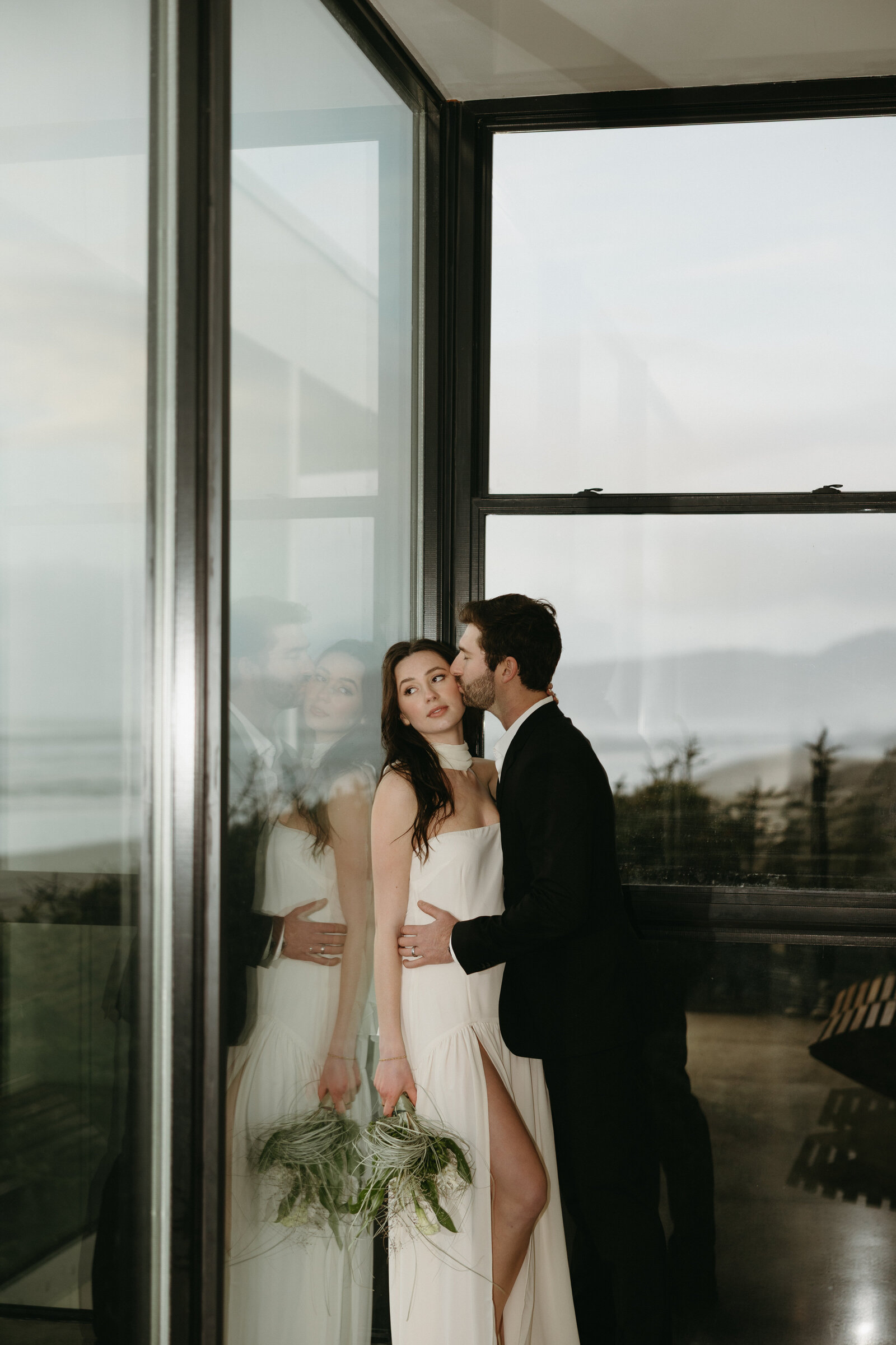 A groom kisses his bride on the cheek after getting married in Vancouver. 