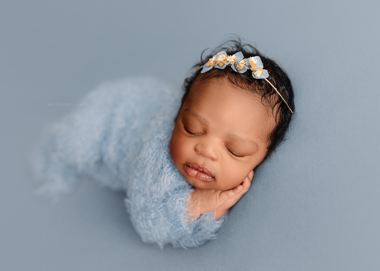 newborn photo shoot in oswego ny studio wearing baby blue and posed sleeping