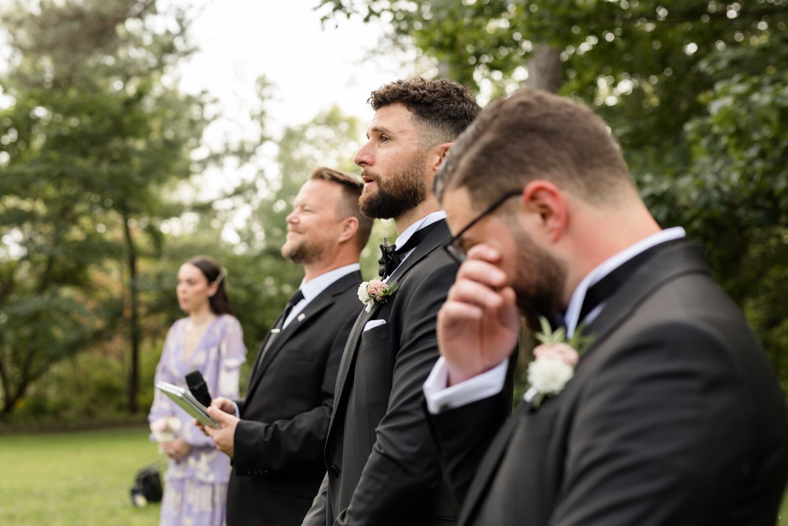 Groom-and-grooms-brother-emotional-seeing-bride-coming-down-the-aisle-at-an-outdoor-elsie-perrin-williams-estate-wedding-ceremony