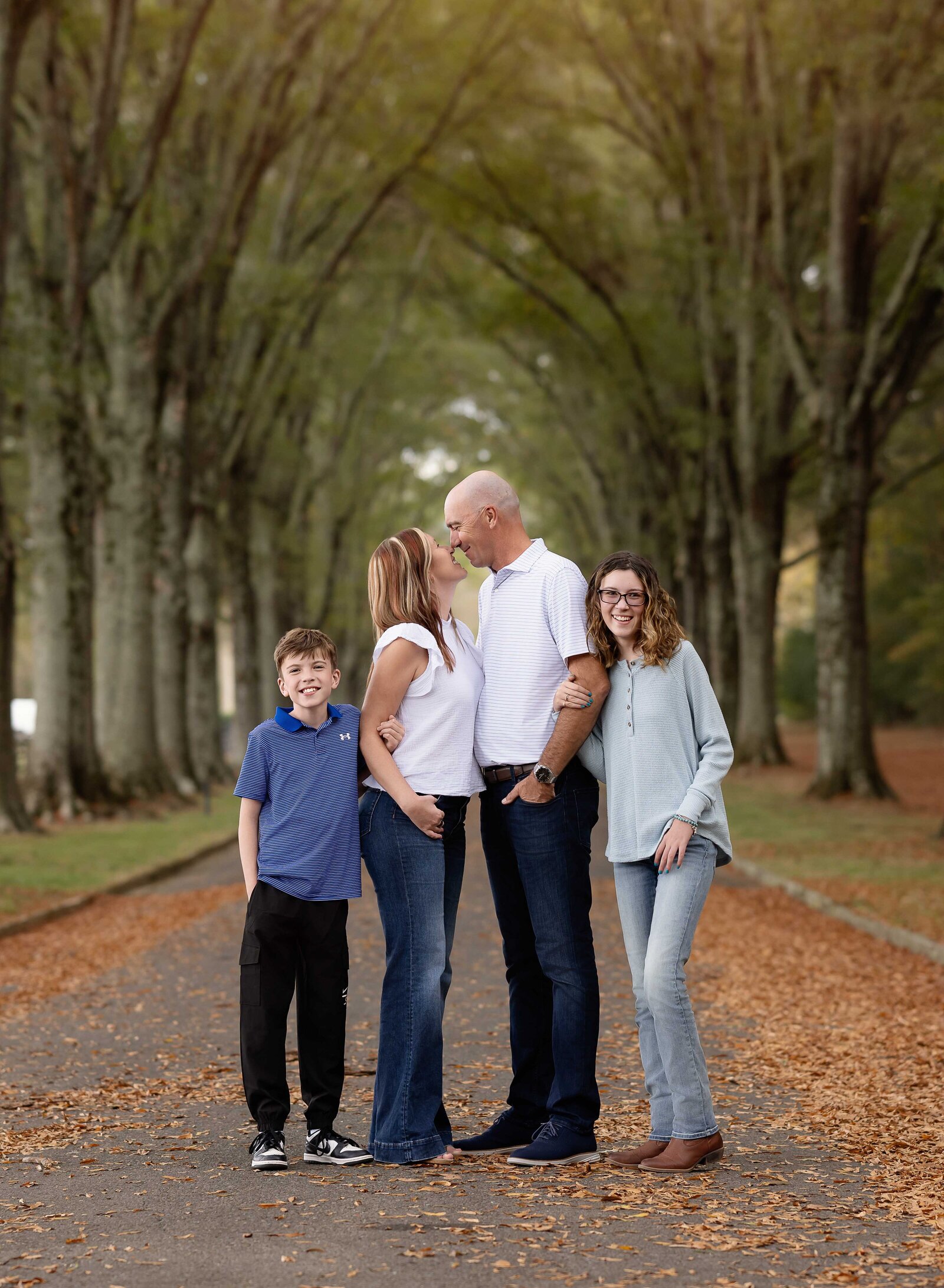 Family of 4 posing for a family photoshoot. Mom and Dad looking at each other and kids looking at camera. Family Photography by Jenni Nikki Photography- Atlanta Family Photographer.
