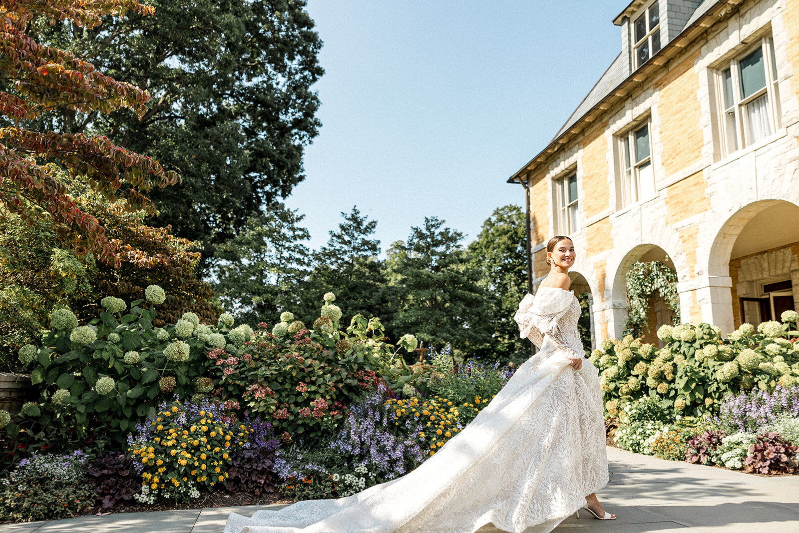 Bride picking up her dress with flowers in the back at Carniwood Estate