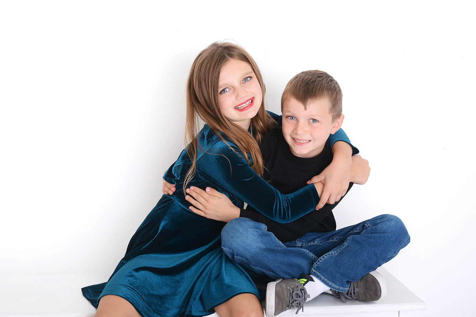 brother and sister smile together at their photoshoot