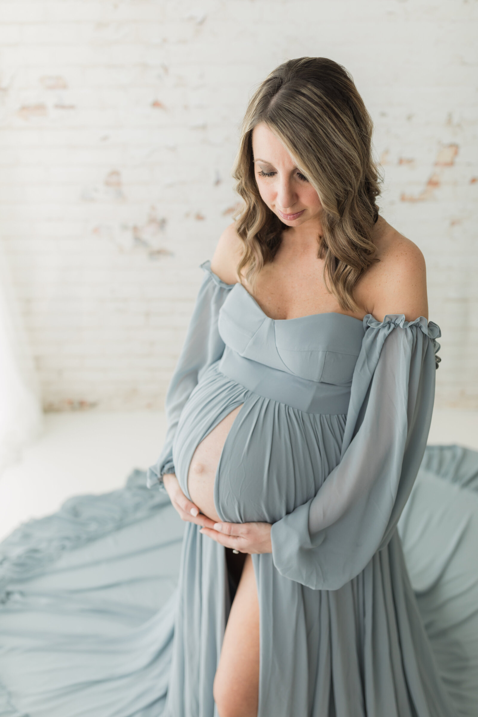 pregnant mother in blue maternity gown holding baby bump for maternity photoshoot cleveland maternity photographer