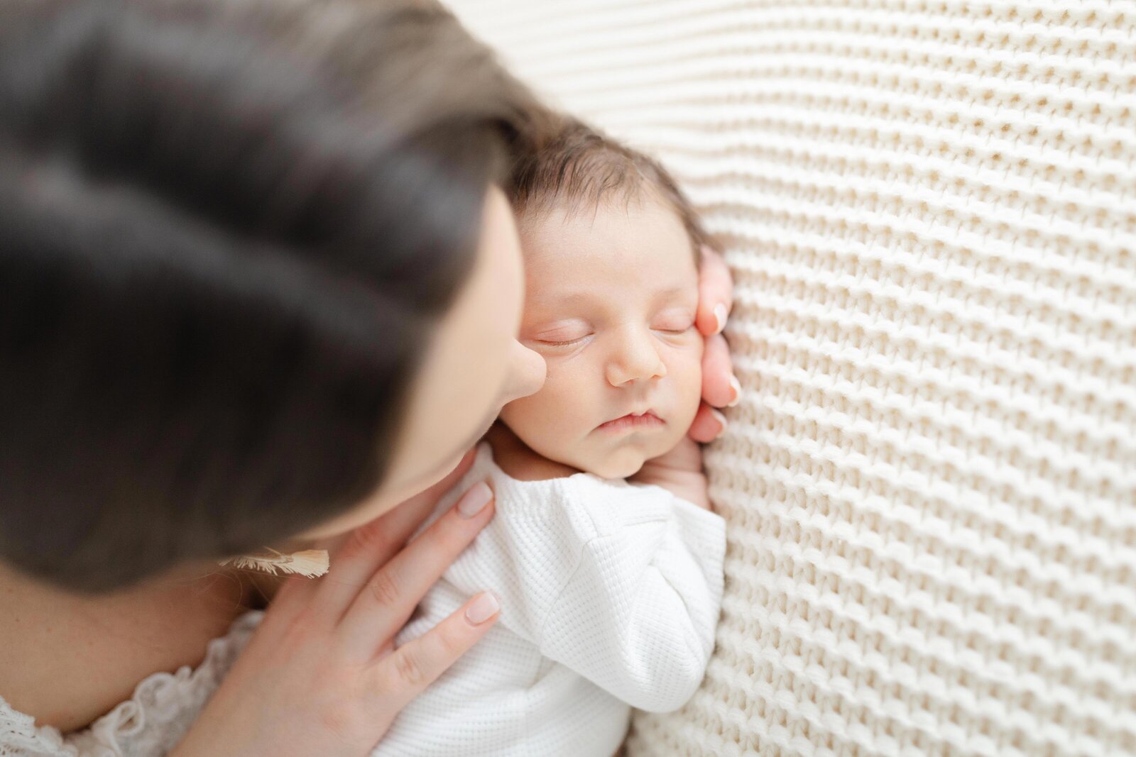 Mom cuddling sleeping baby