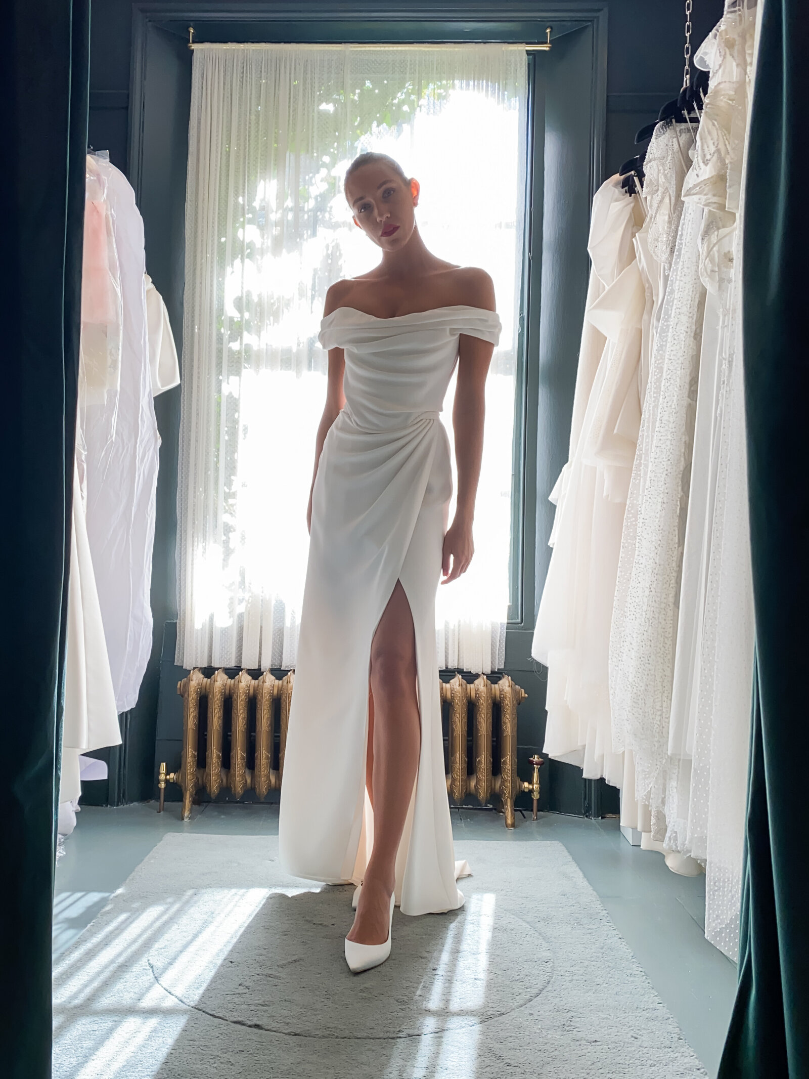bride wearing off the shoulder white satin wedding dress with high slit