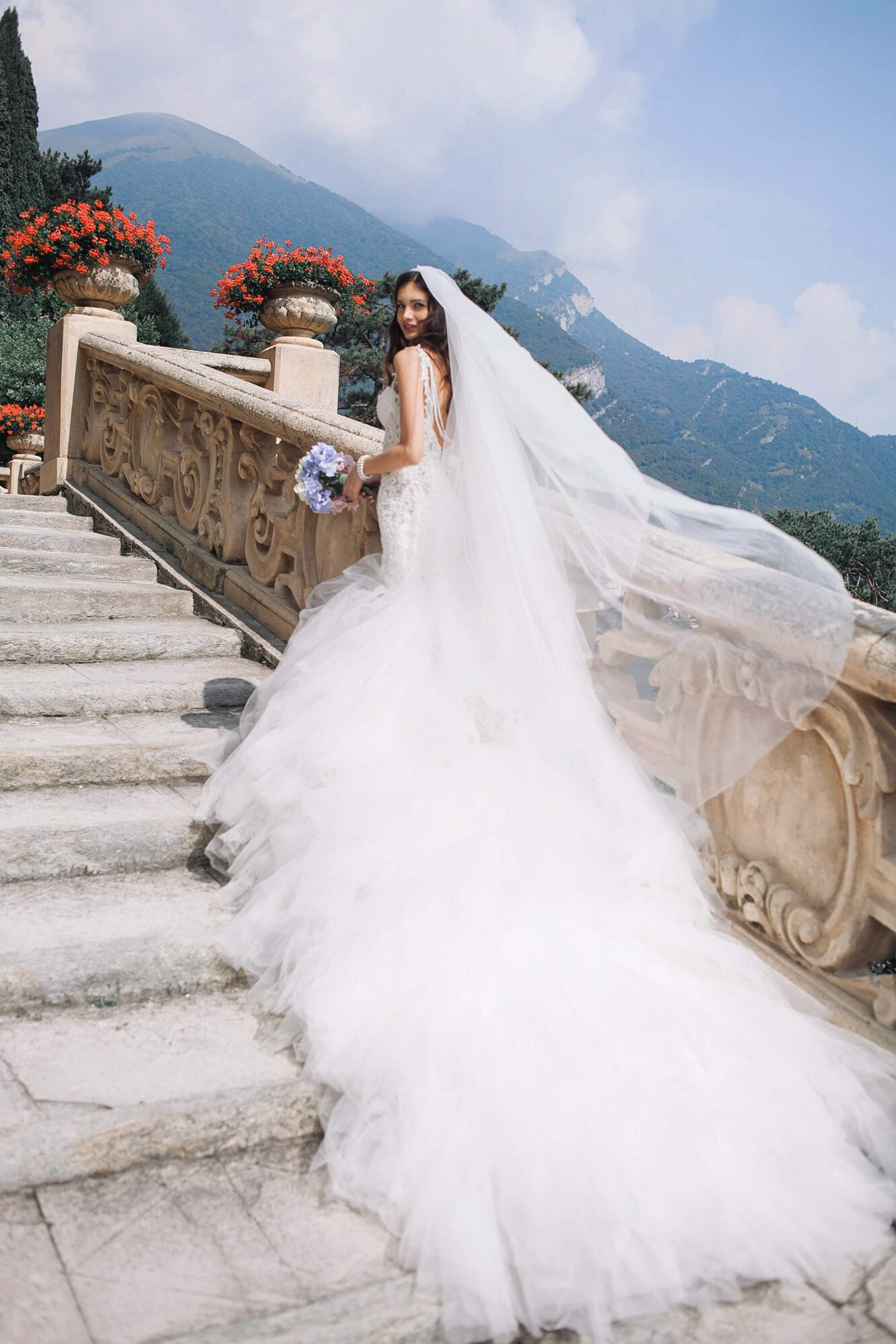 Bride wearing her grand wedding gown walking up the stairs
