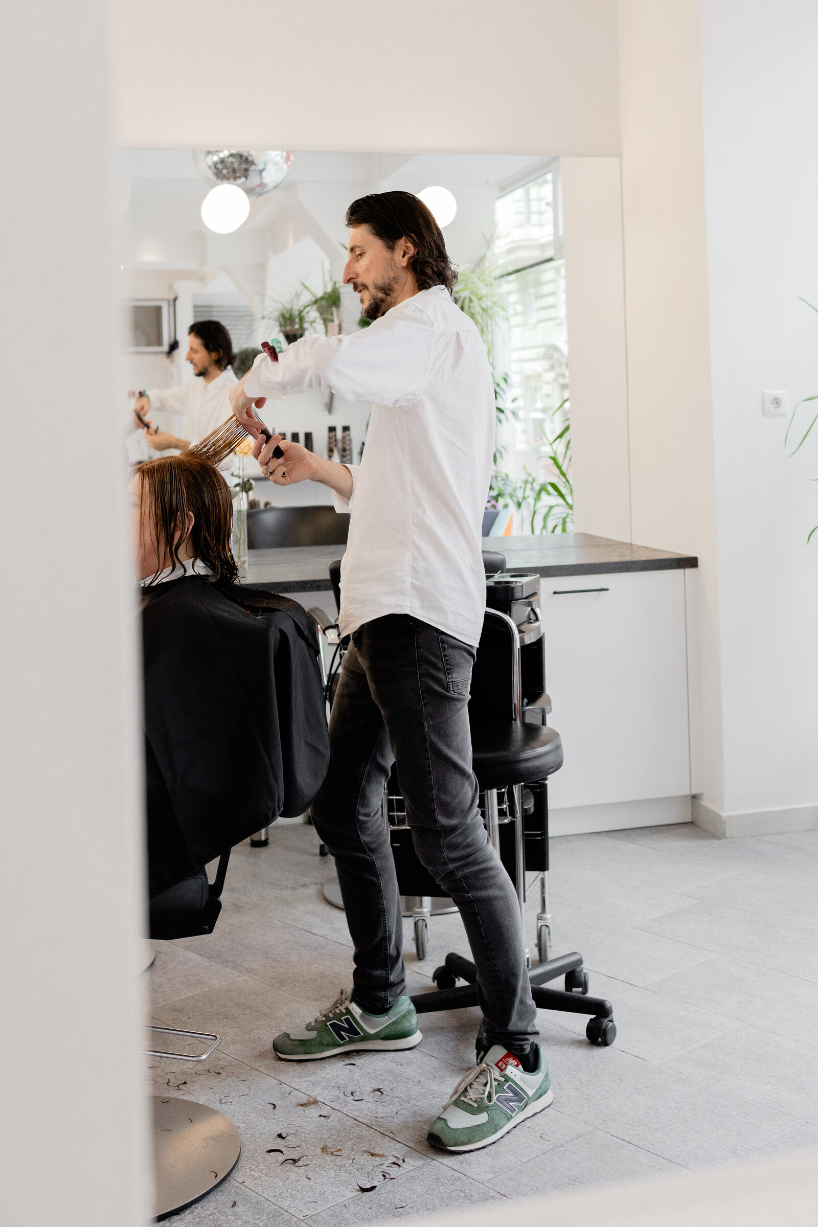 Friseur frisiert ein Mädchen