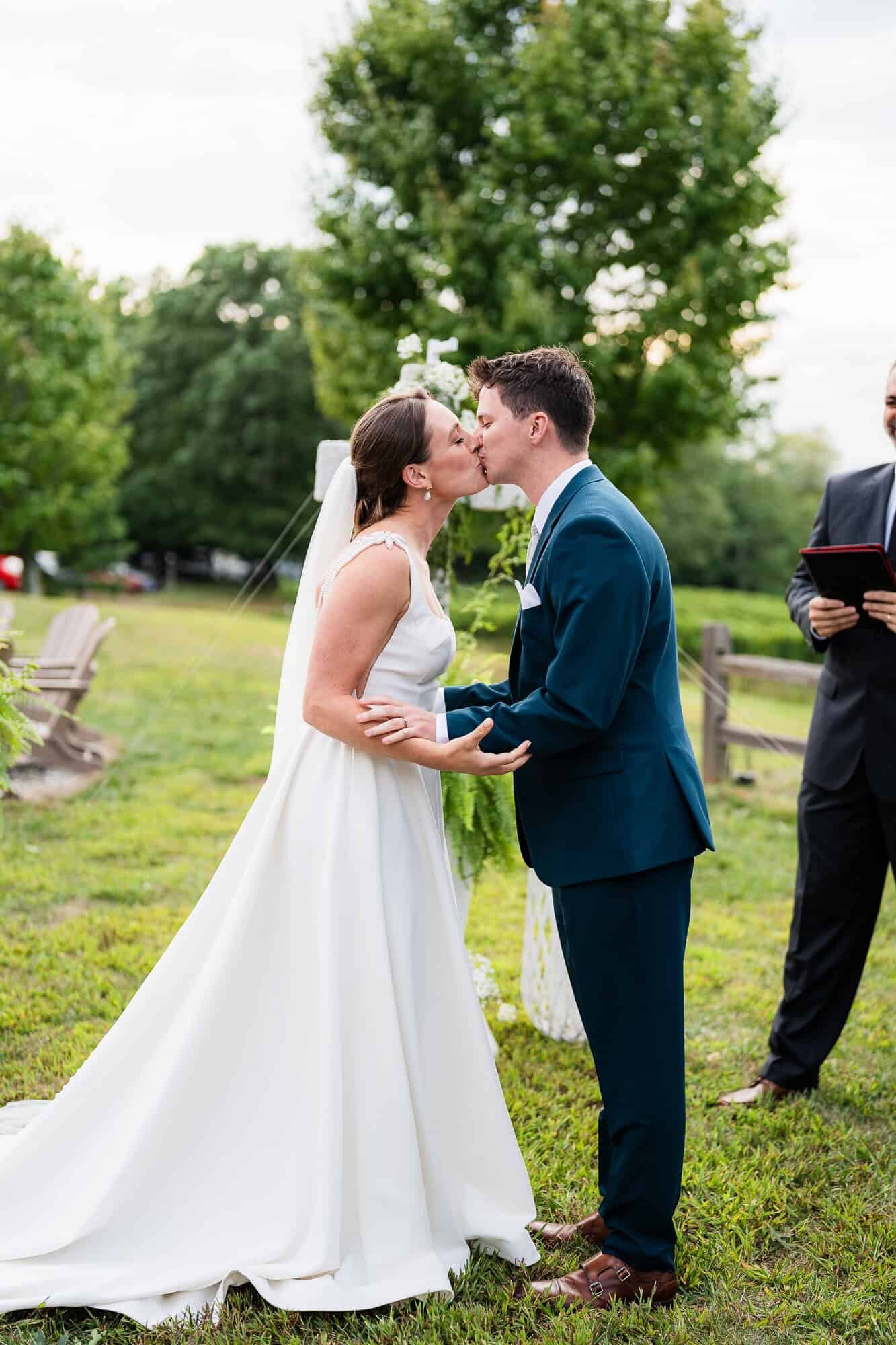 bride and groom first kiss during their wedding ceremony at terra incognita vineyard wedding venue 