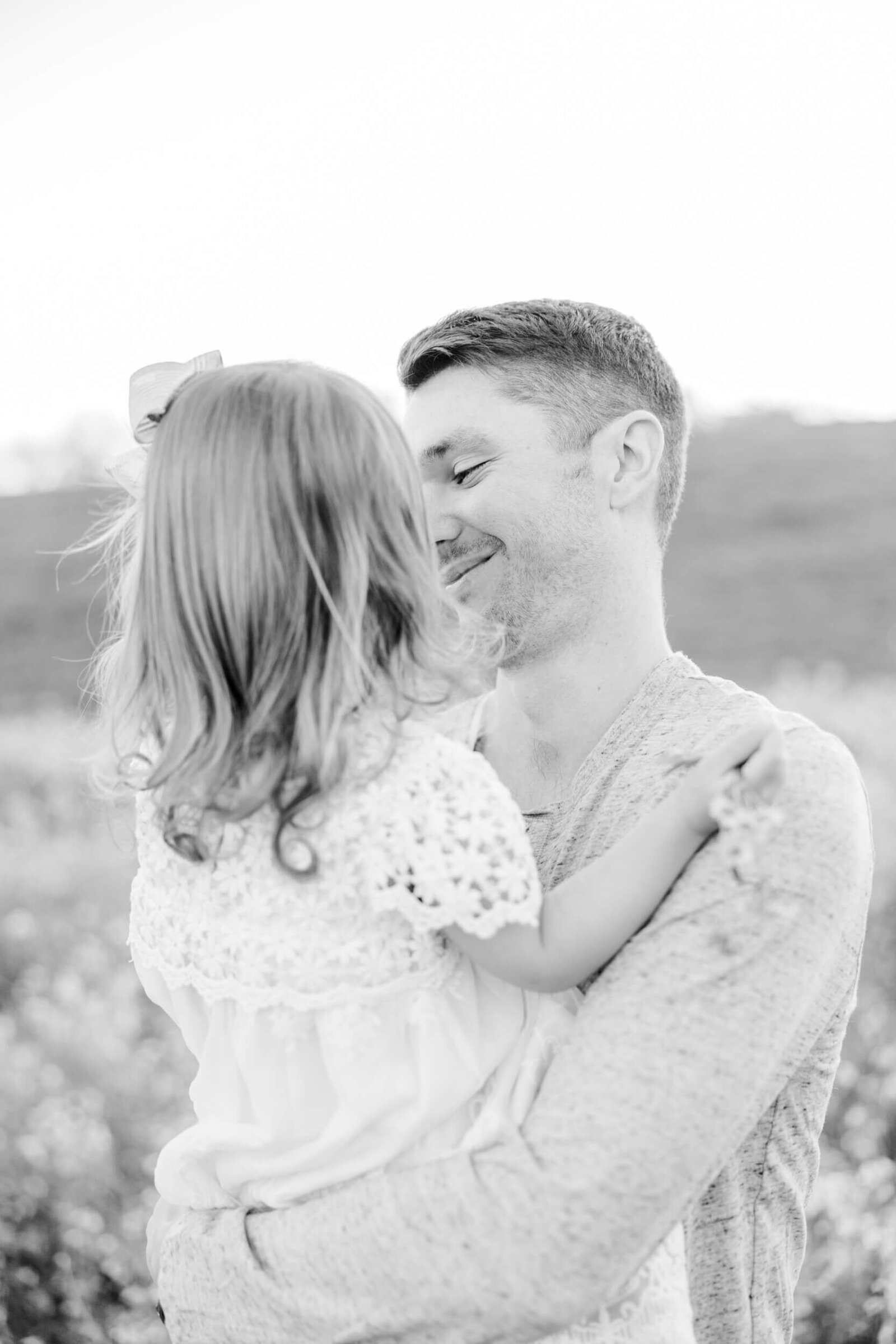 Black and white, dad smiles at his daughter