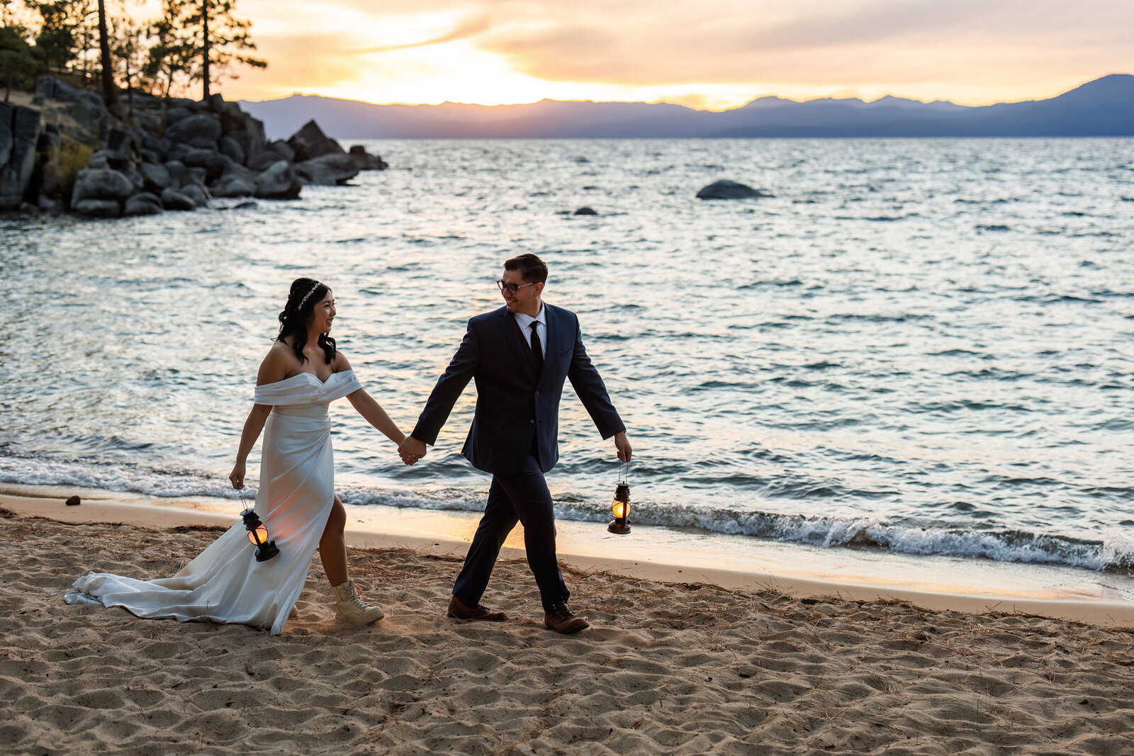 a bride and groom walk along the beach at lake tahoe