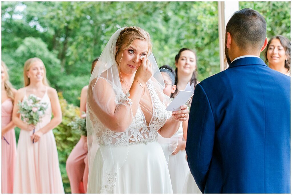 bride crying as she reads her wedding vows