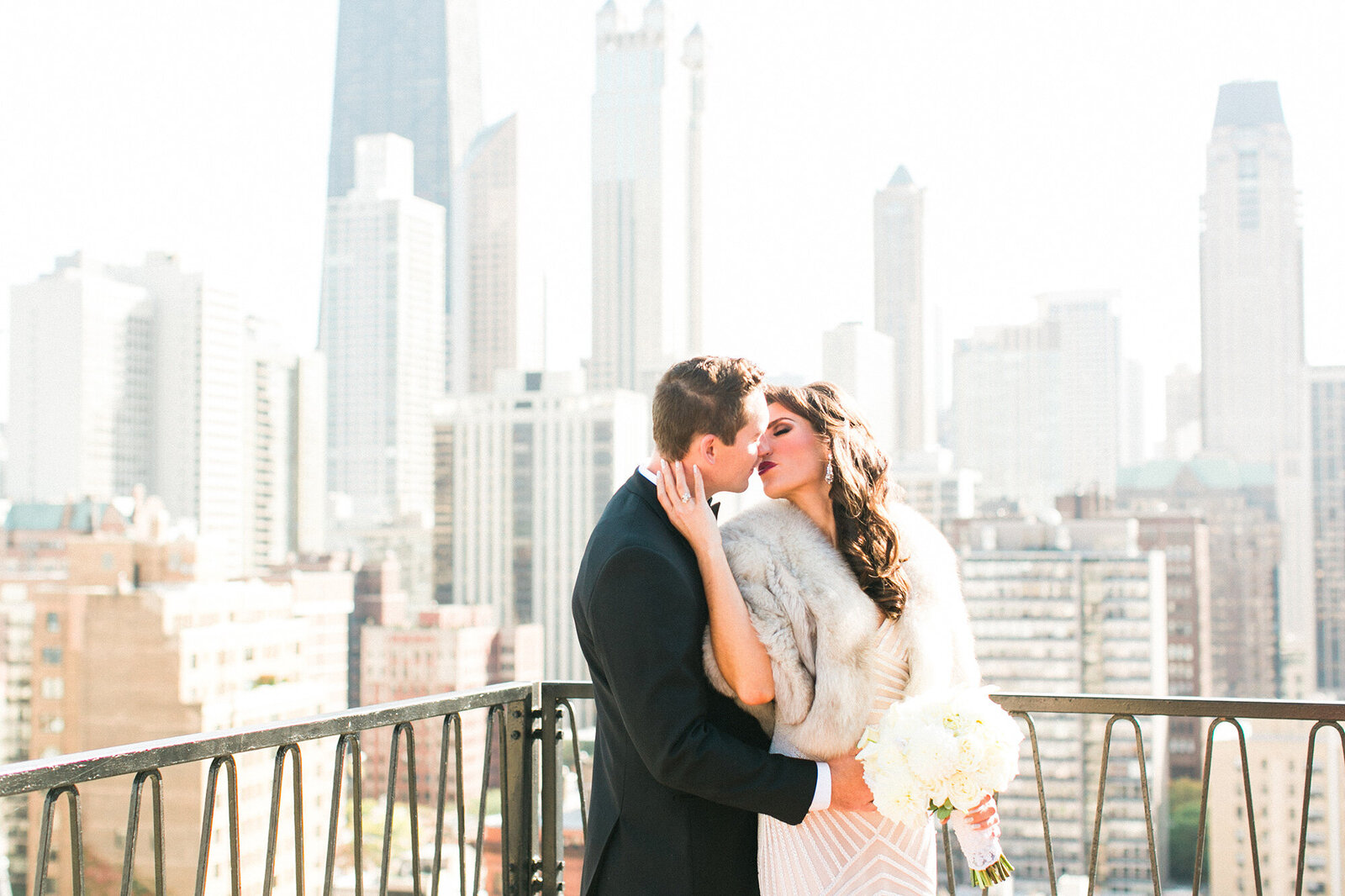 A romantic wedding day portrait on a rooftop with the city skyline of Chicago behind them.