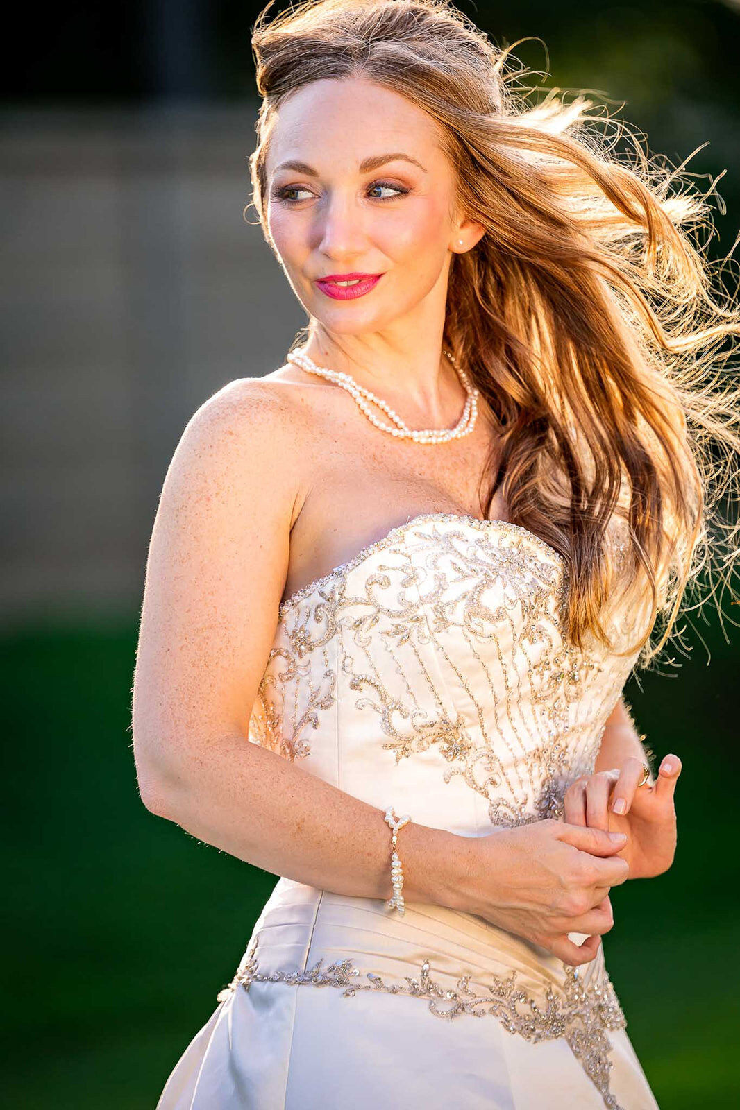 A radiant bride captured in soft natural light, with the wind blowing through her hair during an outdoor wedding photoshoot. Photographed by CMH Studios, a San Antonio luxury wedding photographer.