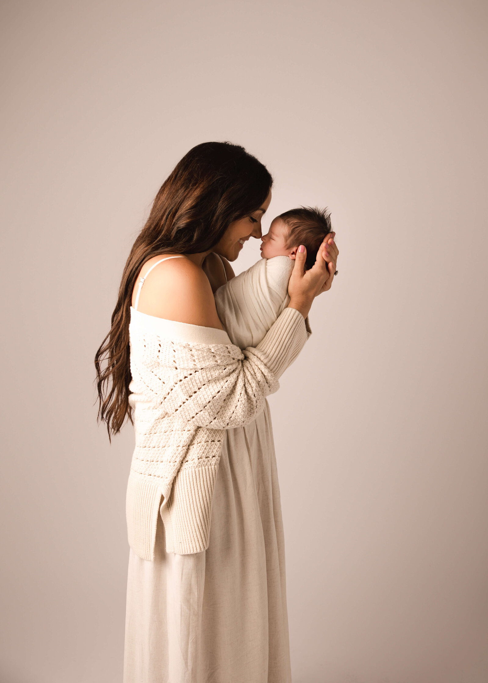 New mom holding her baby boy in newborn session by Ashley Nicole.
