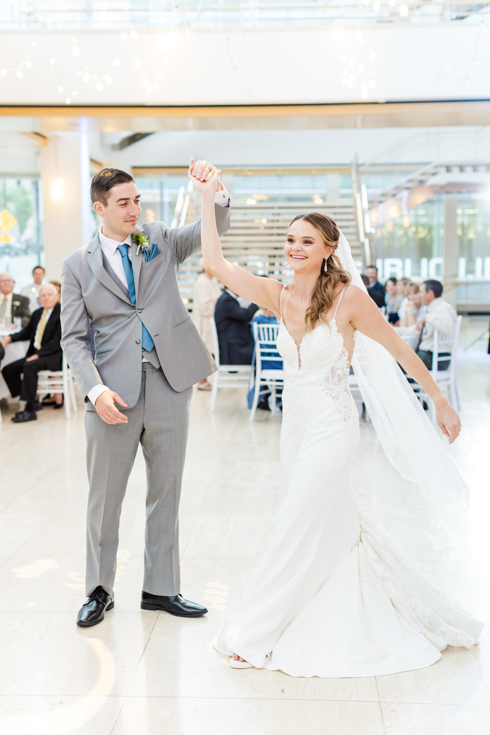 25_couple_smiling_during_first_dance_at_the_overture_center_lobby_wedding
