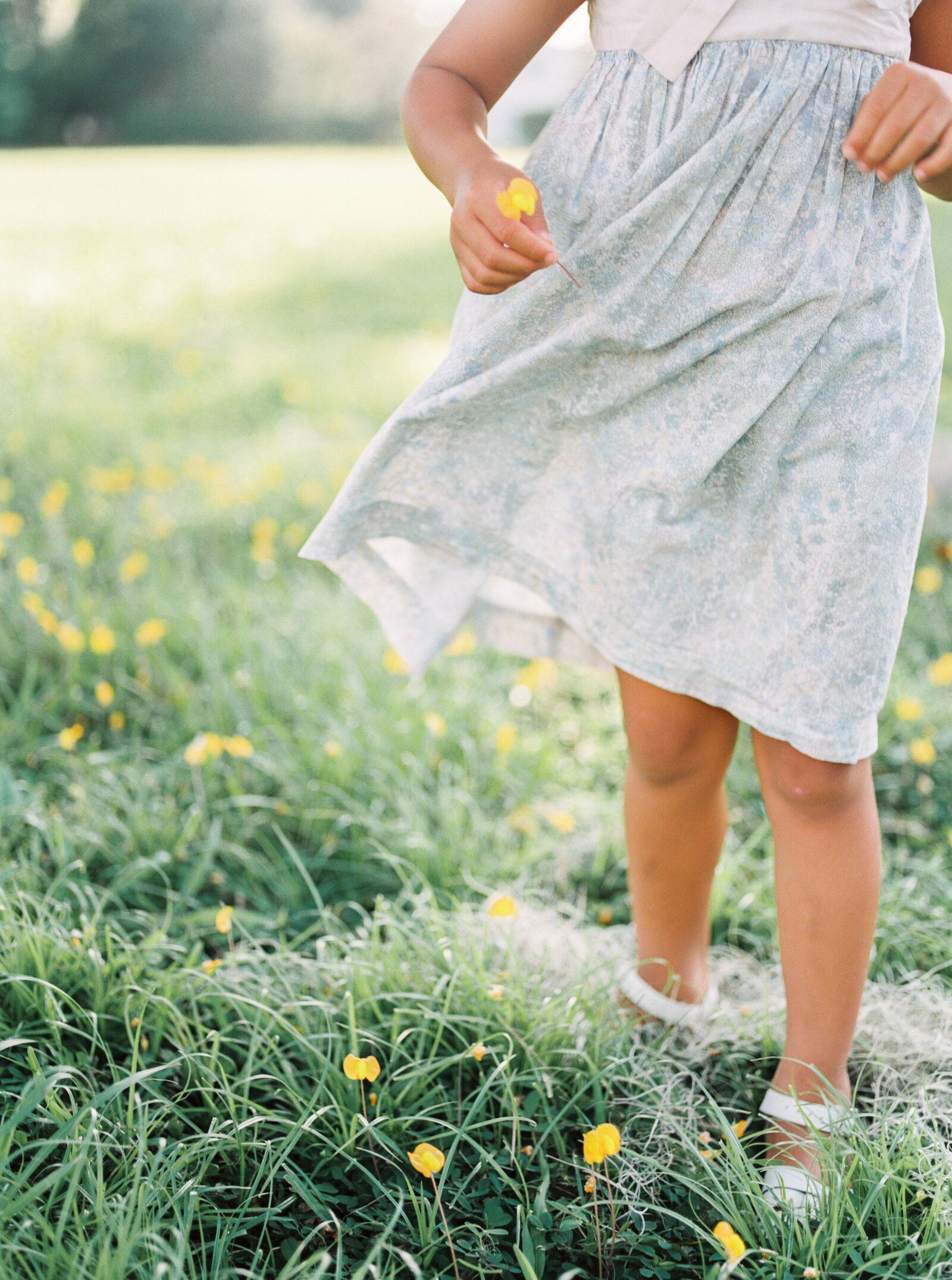 little girl holding flowers at the park by Orlando lifestyle photographer