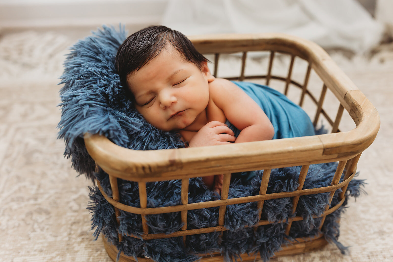 Babu boy with beautiful black hair sleeping in a basket